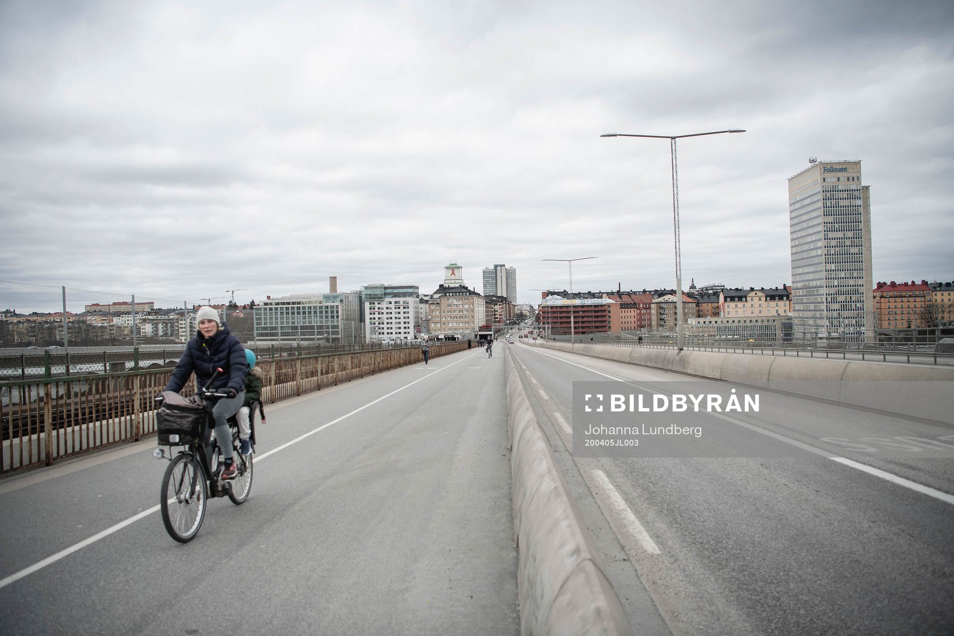 People bicycle at the Skanstull bridge as the coronavirus,
