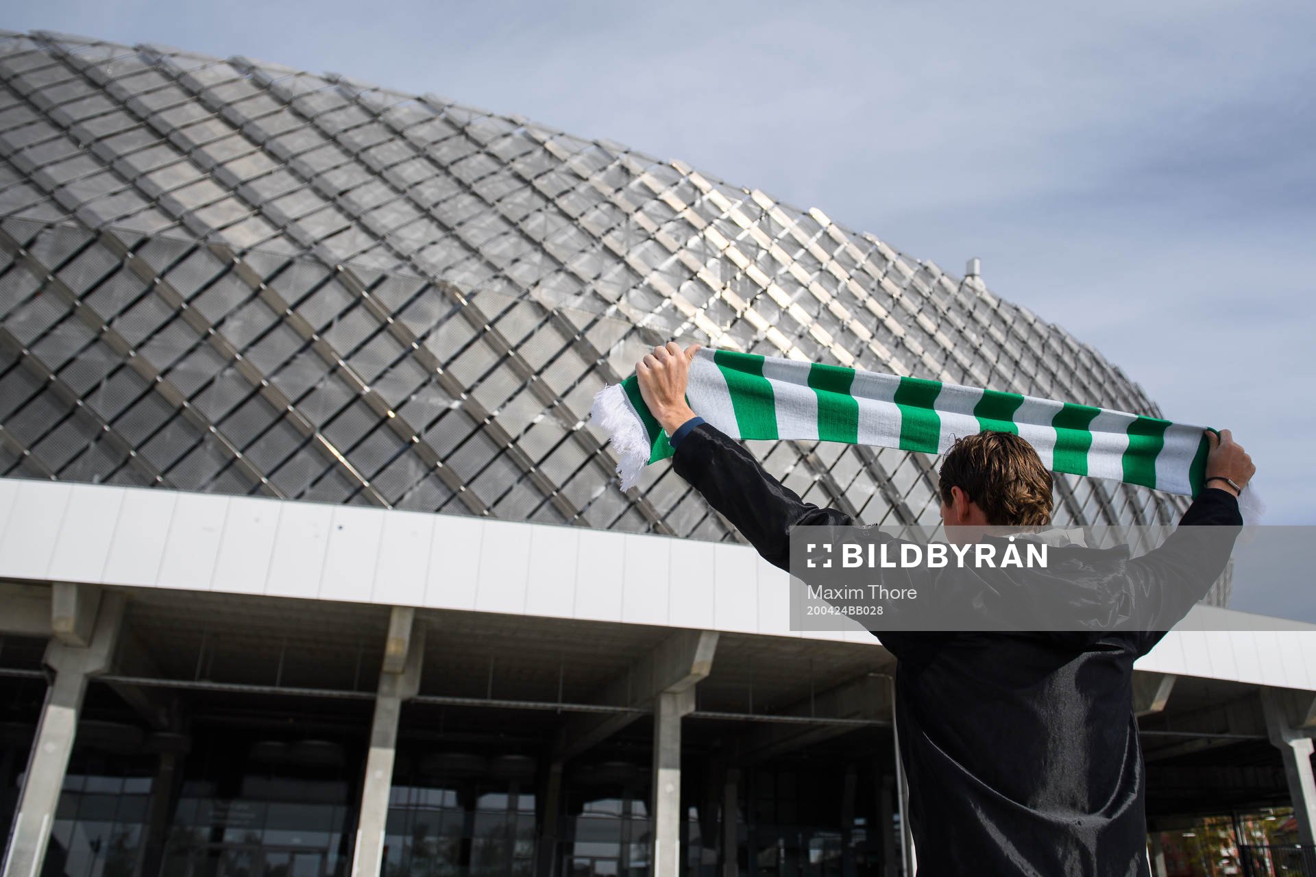 En person poserar med en Hammarbyhalsduk utanför Tele2