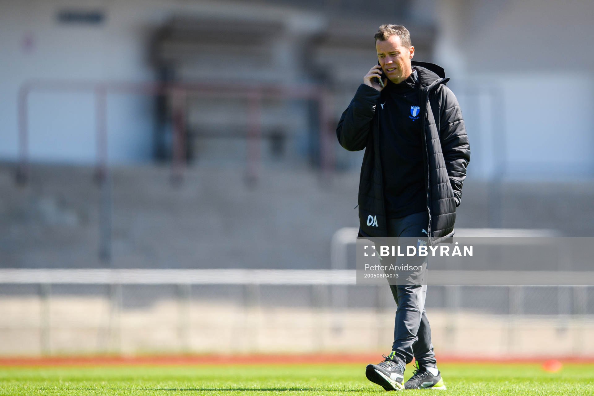 Sportchef Daniel Andersson pratar i telefon under en fotbollsträning med Malmö FF den 8 maj 2020 i Malmö.