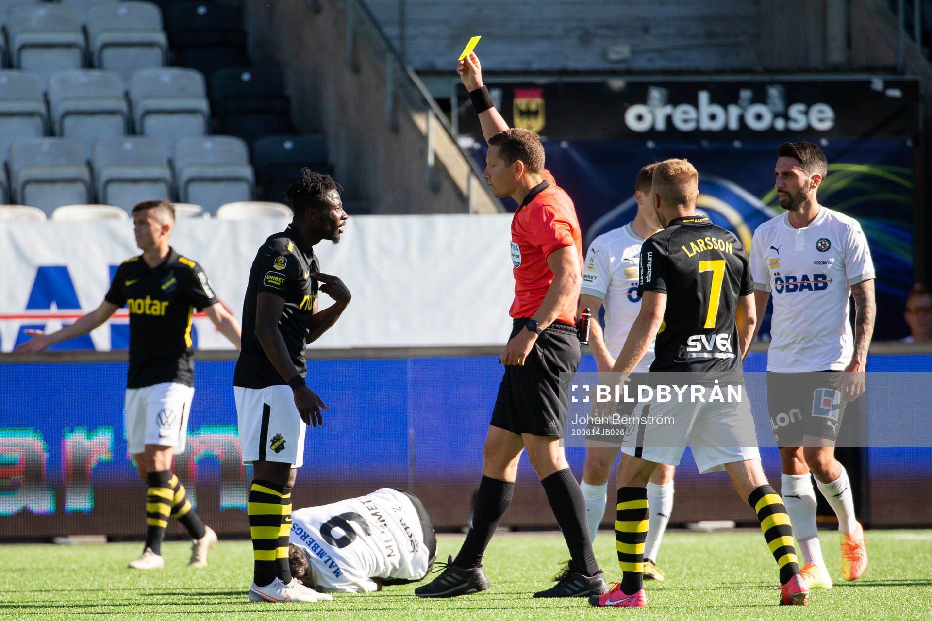 s Ebenezer Ofori får gult kort av domare Martin