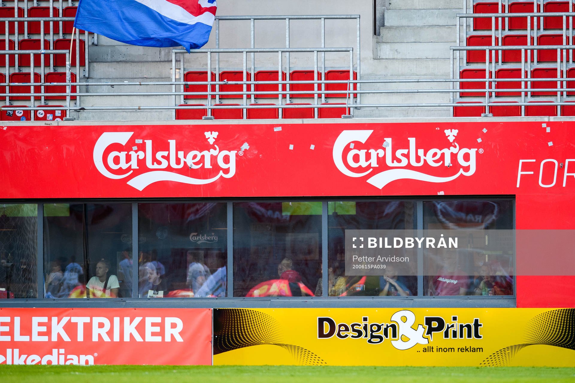 Besökare på en sportbar följer fotbollsmatchen i