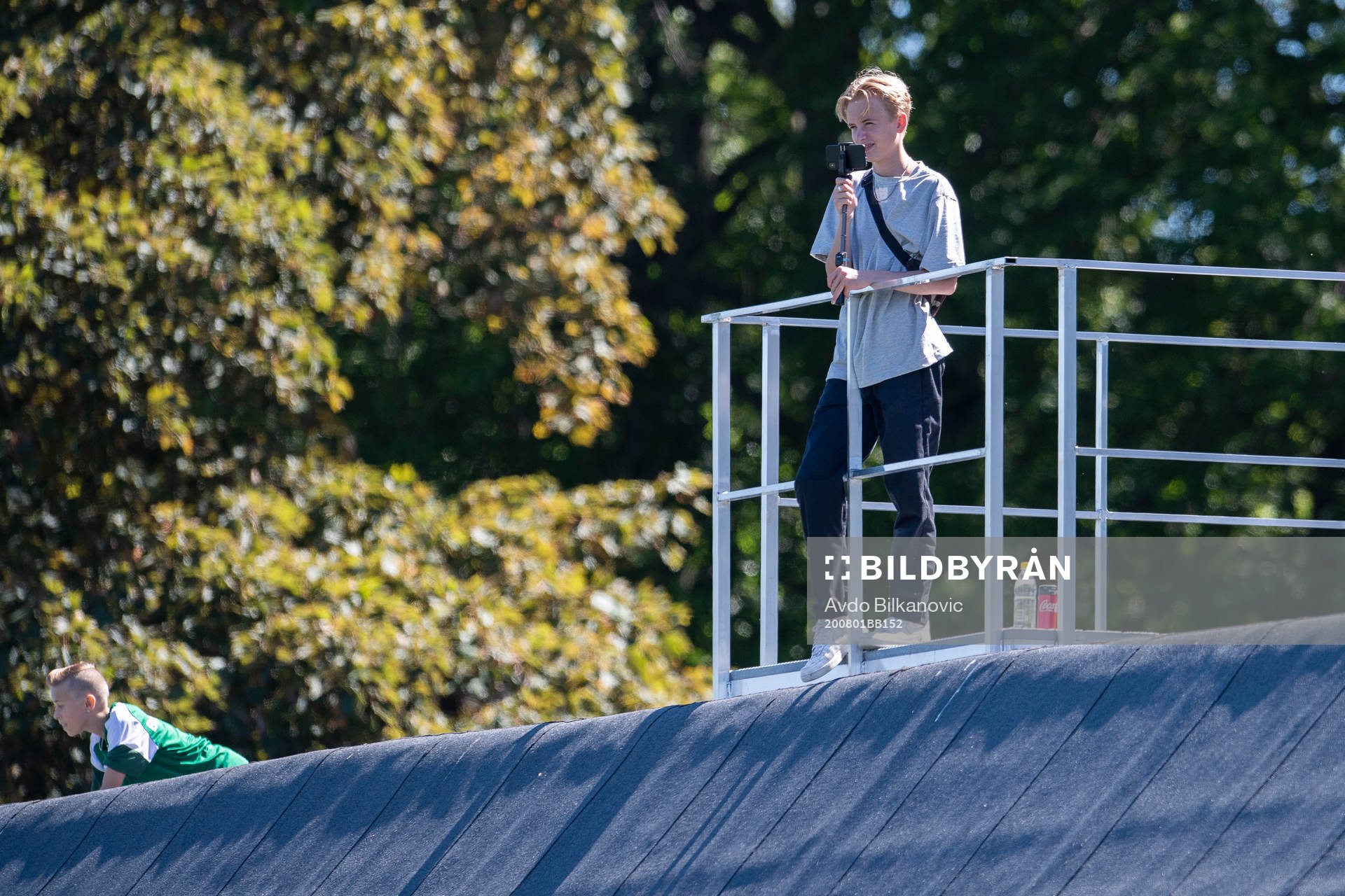 En pojke filman matchen med telefonen under fotbollsmatchen i Division 4 Sydvästra mellan Limhamn och Rosengård den 1 augusti 2020 i Malmö.