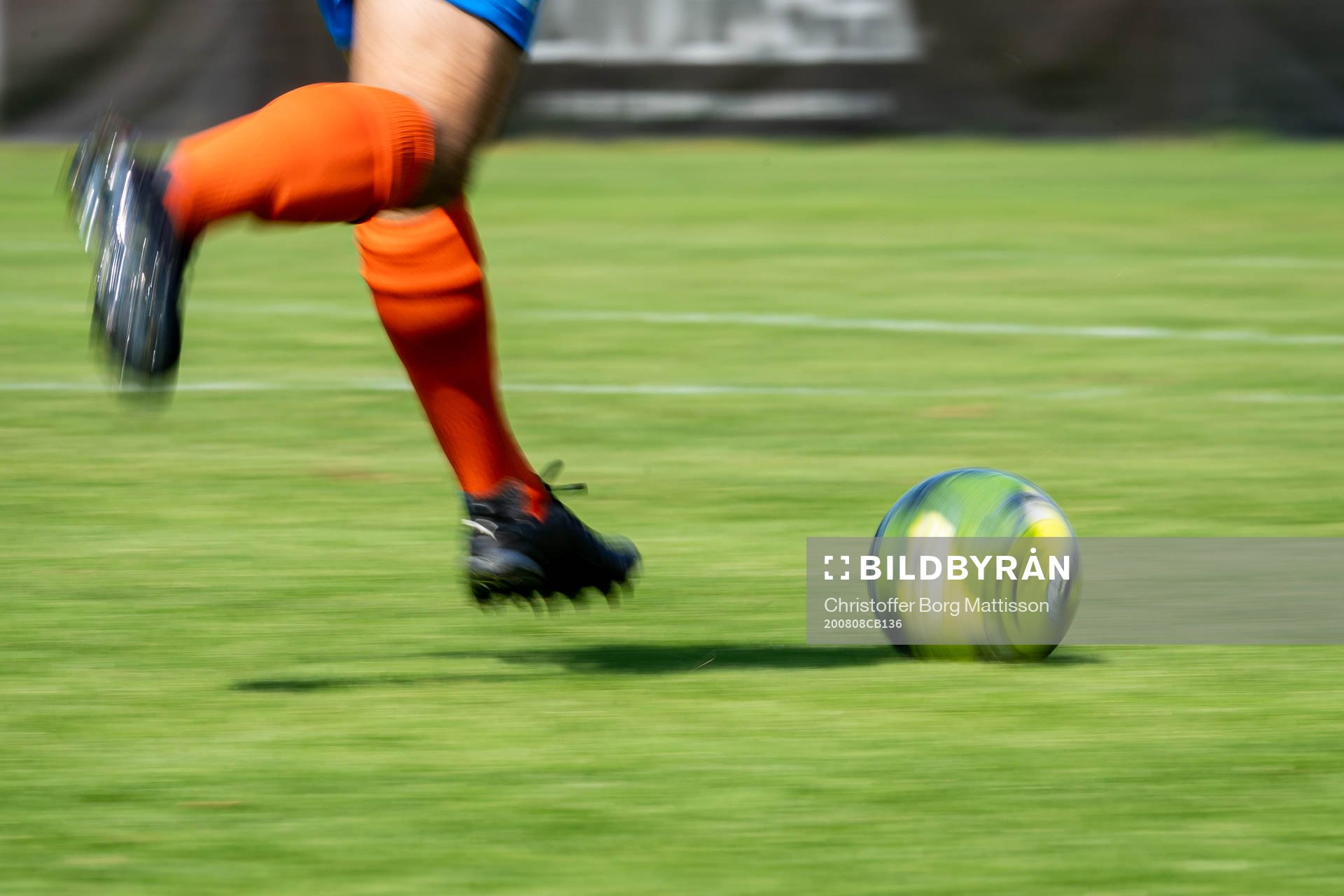 En fotbollsspelare springer med bollen