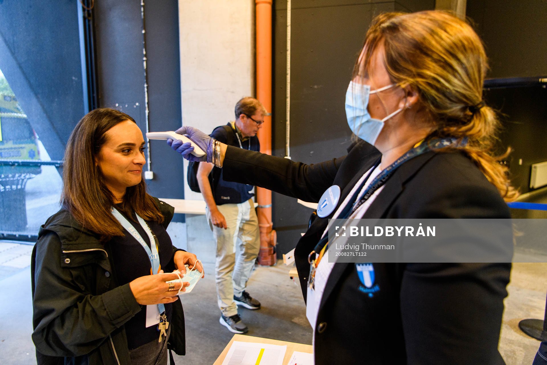 Staff check temperature of arriving media