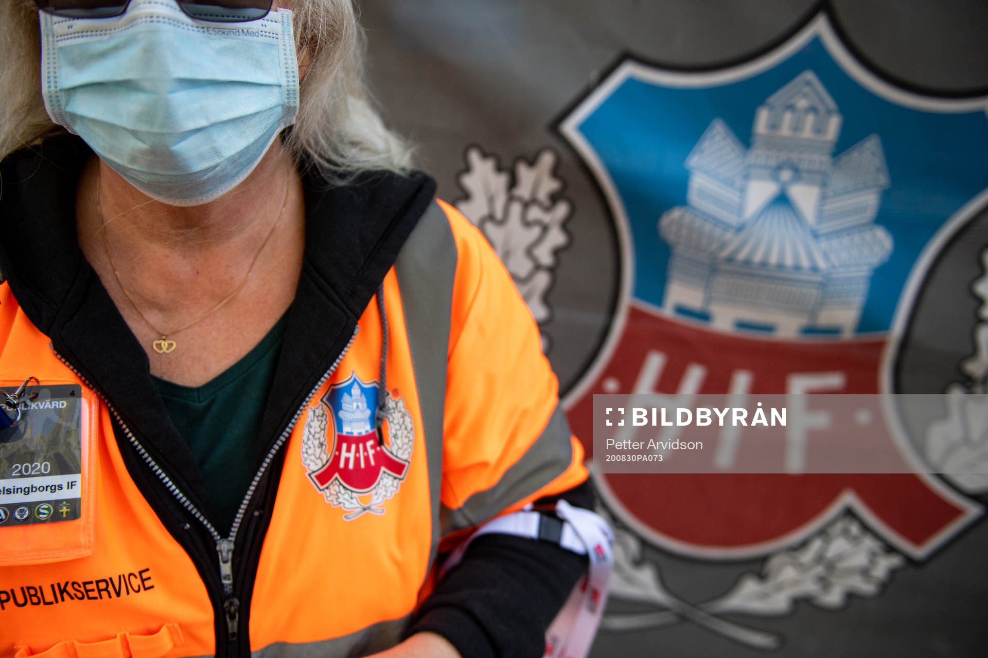 Publikvärd med ansiktsmask vid insläppet