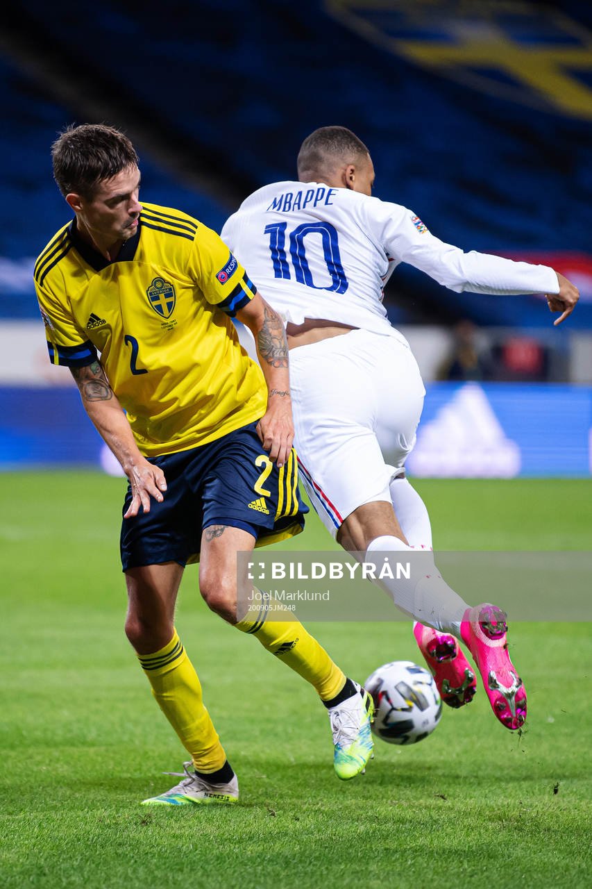 Mikael Lustig of Sweden is being dribbled by Kylian Mbappé