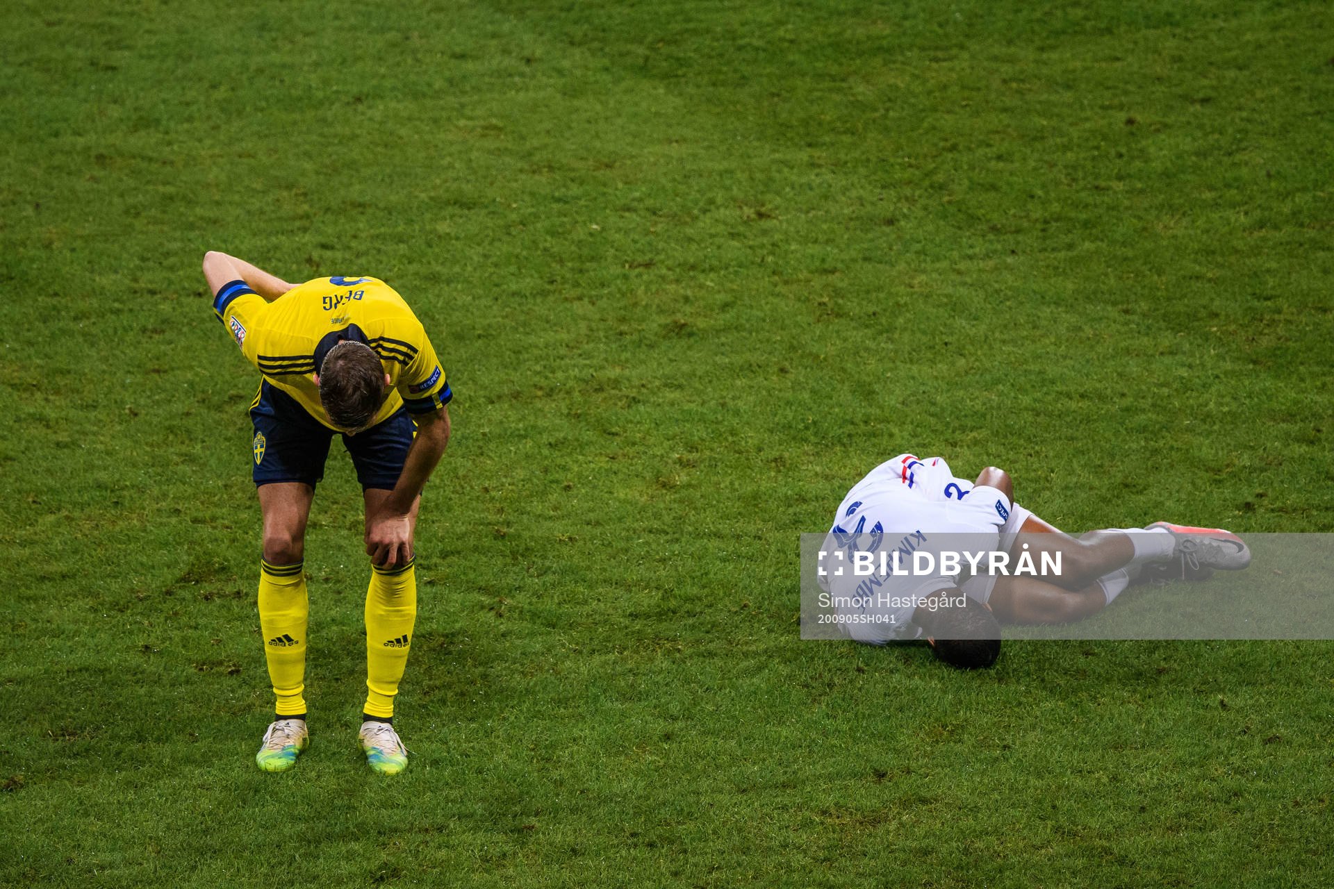 Marcus Berg of Sweden and Presnel Kimpembe of France in pain