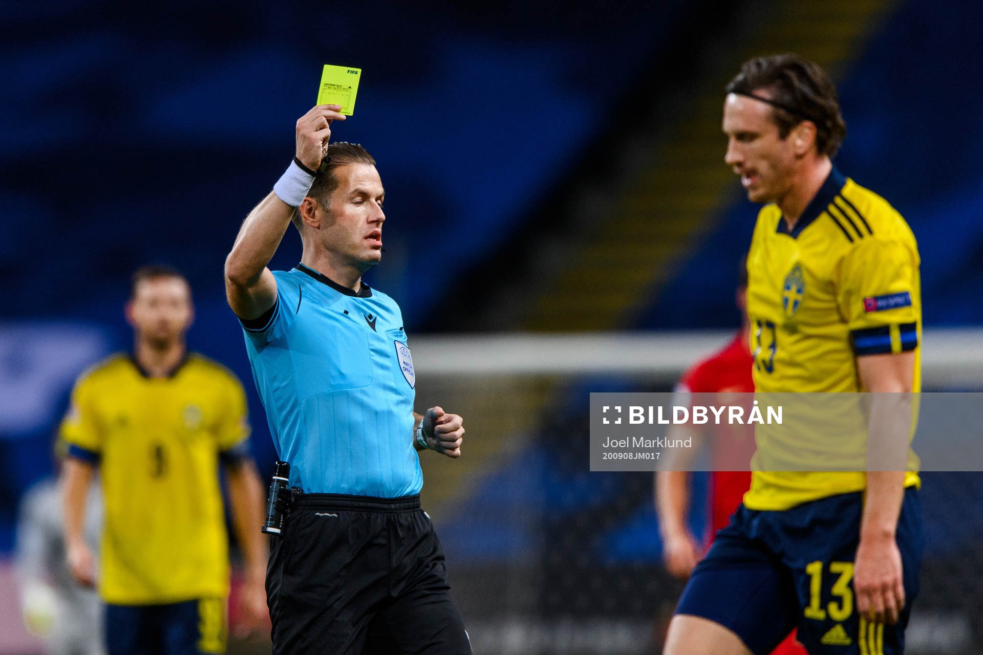Gustav Svensson of Sweden receives a yellow card from