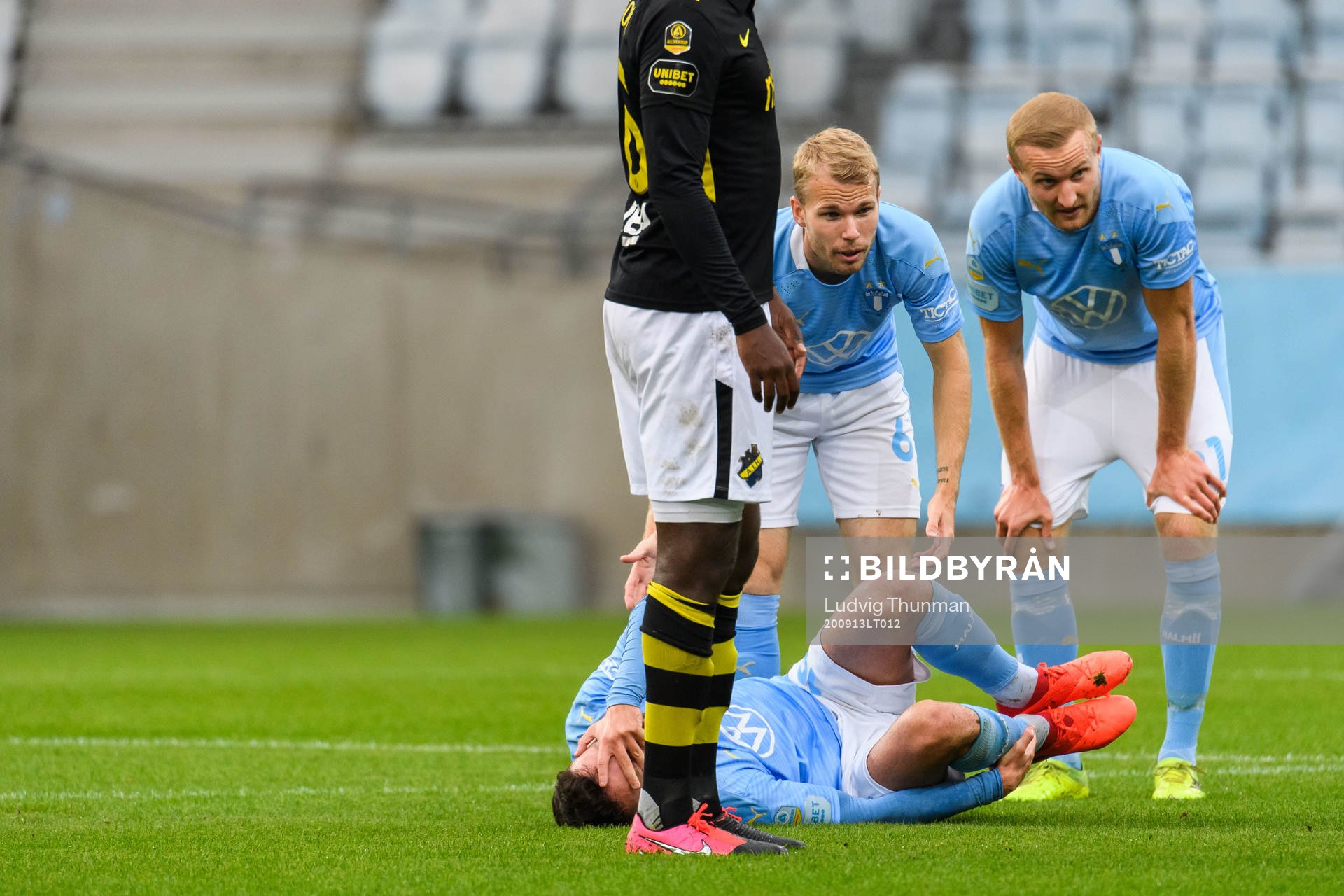Malmö FFs Erdal Rakip har ont och ses om av Oscar Lewicki och Franz Brorsson under fotbollsmatchen i Allsvenskan mellan Malmö FF och AIK den 13 september 2020 i Malmö.
