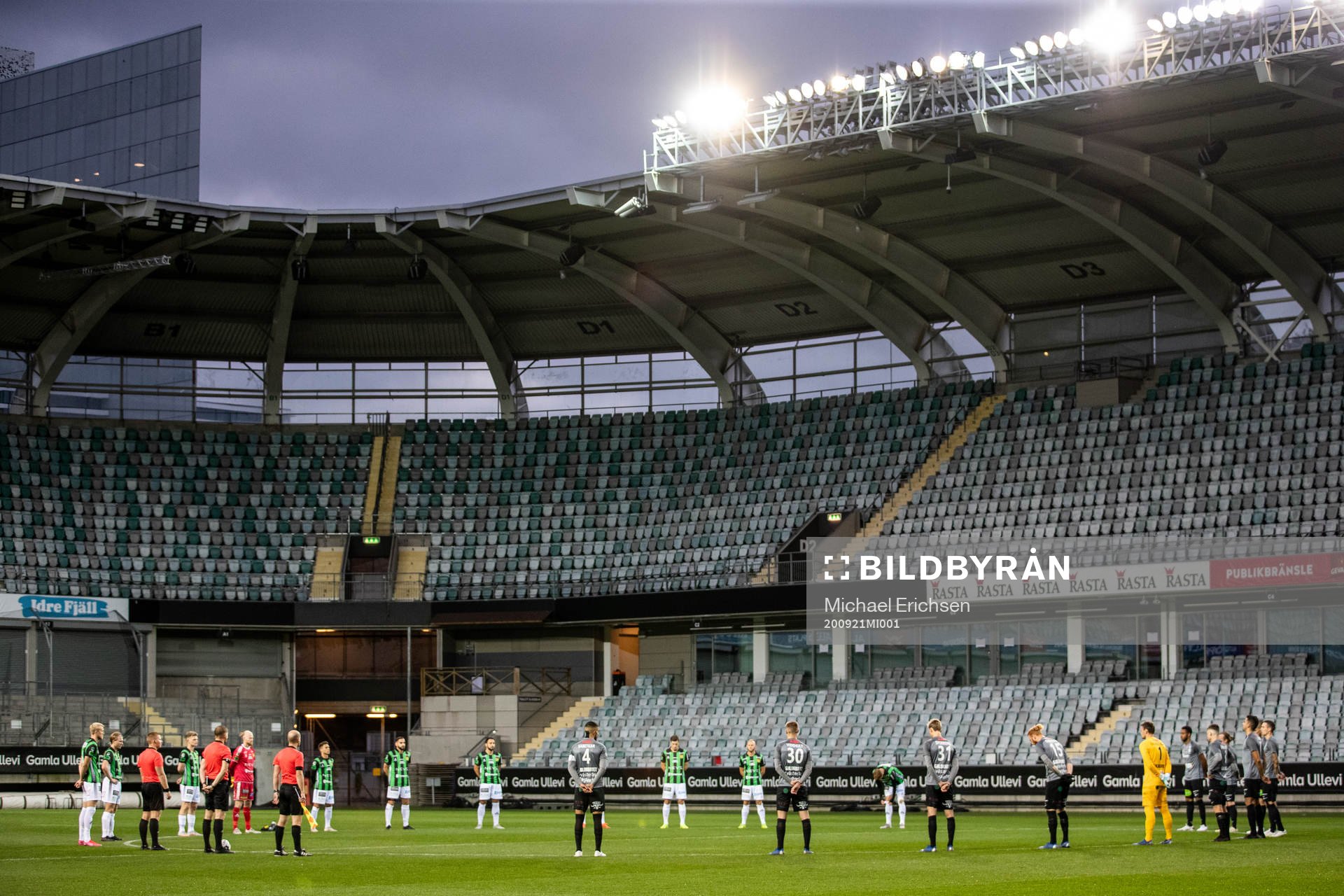 Spelare och domare deltar i en tyst minut för att hedra