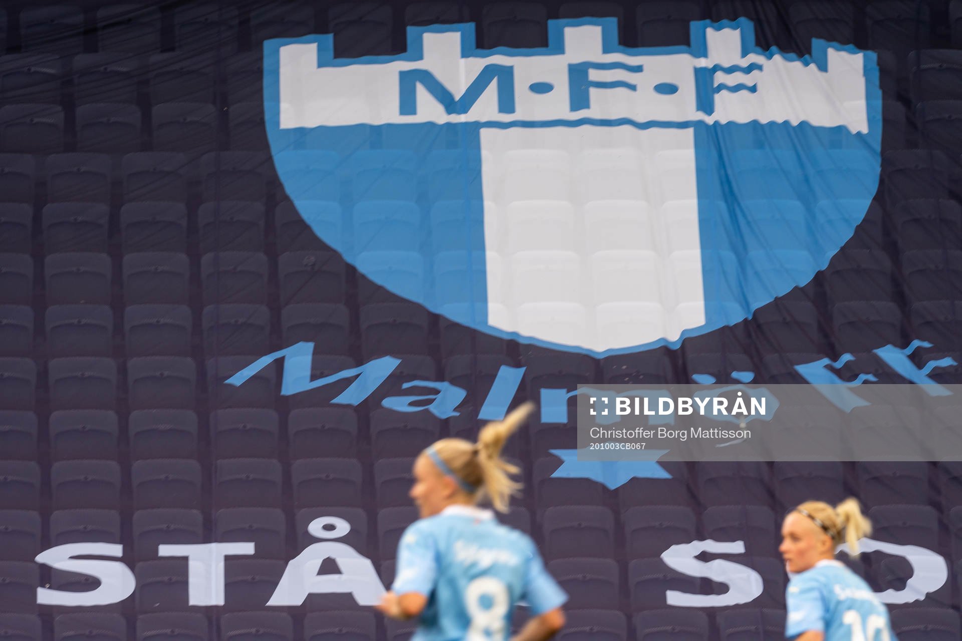 Malmö FFs spelare framför Malmö FFs klubbmärke