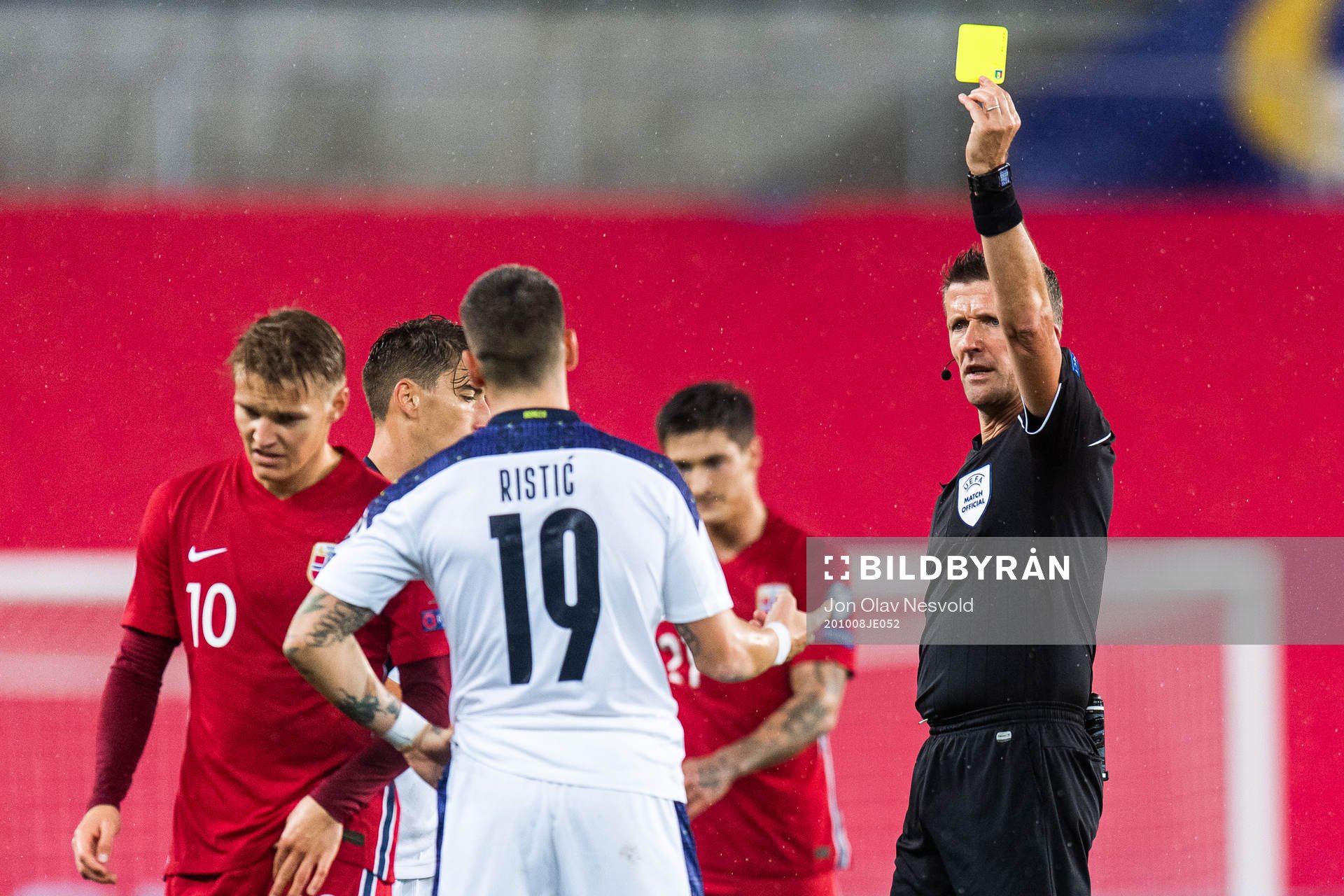 Mihailo Ristic of Serbia receives a yellow card from