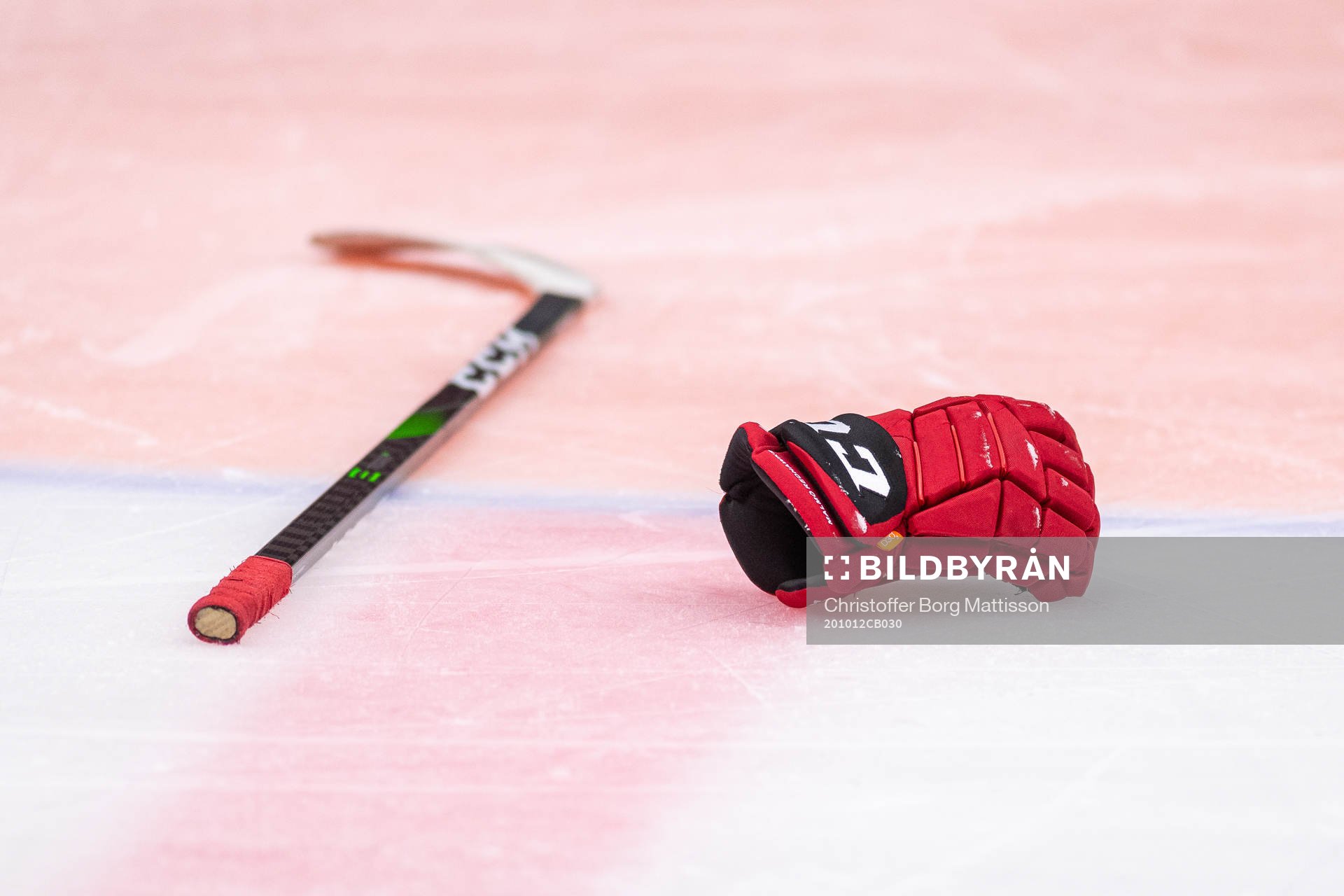 En klubba och en hockeyhandske ligger på isen