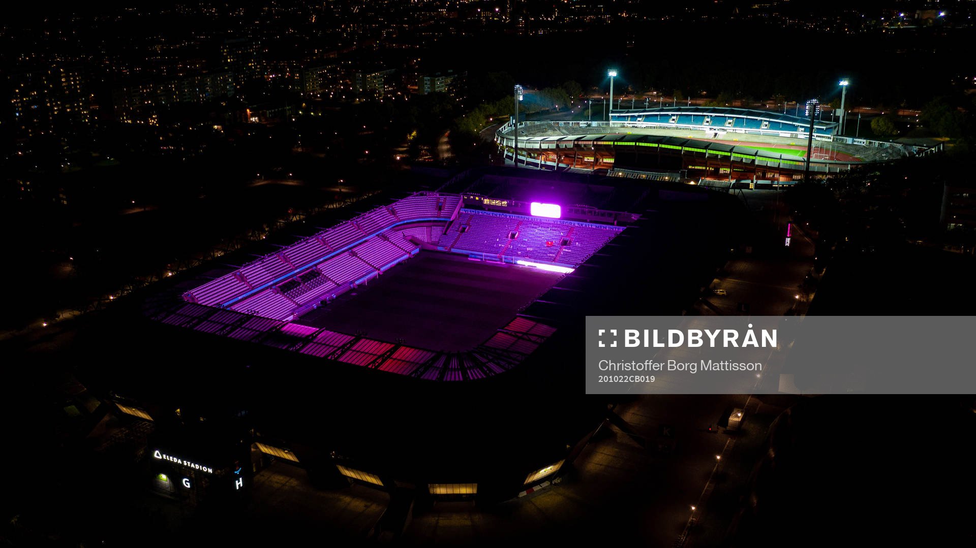 Exteriör vy över Eleda Stadion med rosa ljus på skyltar,