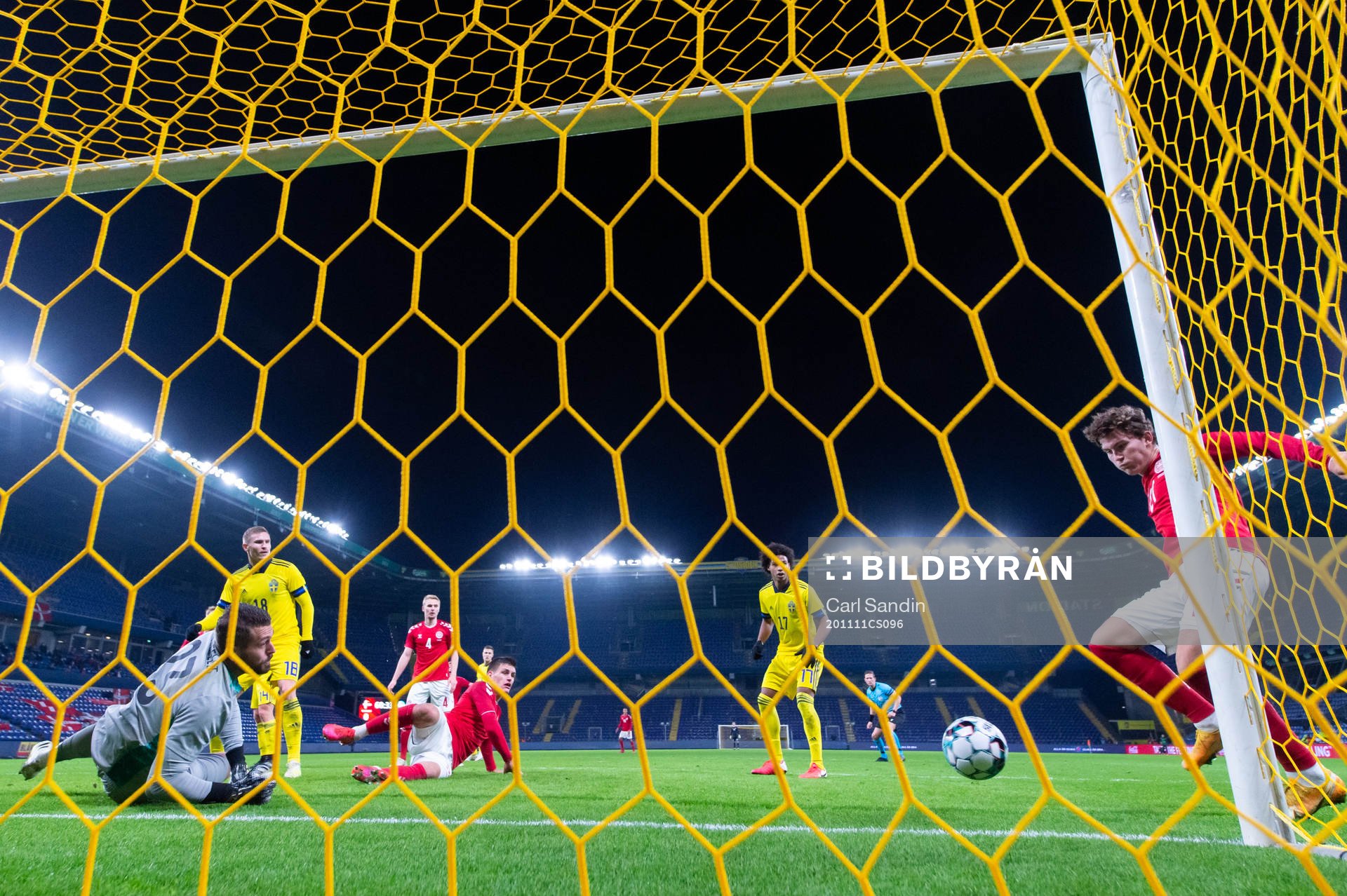 Jonas Wind of Denmark scores 1-0 behind goalkeeper