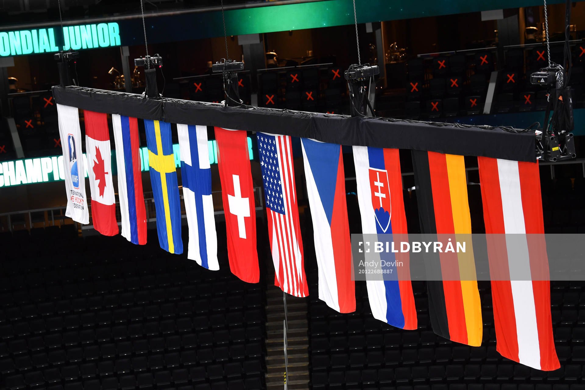 Flags of the participating nations hang above the ice