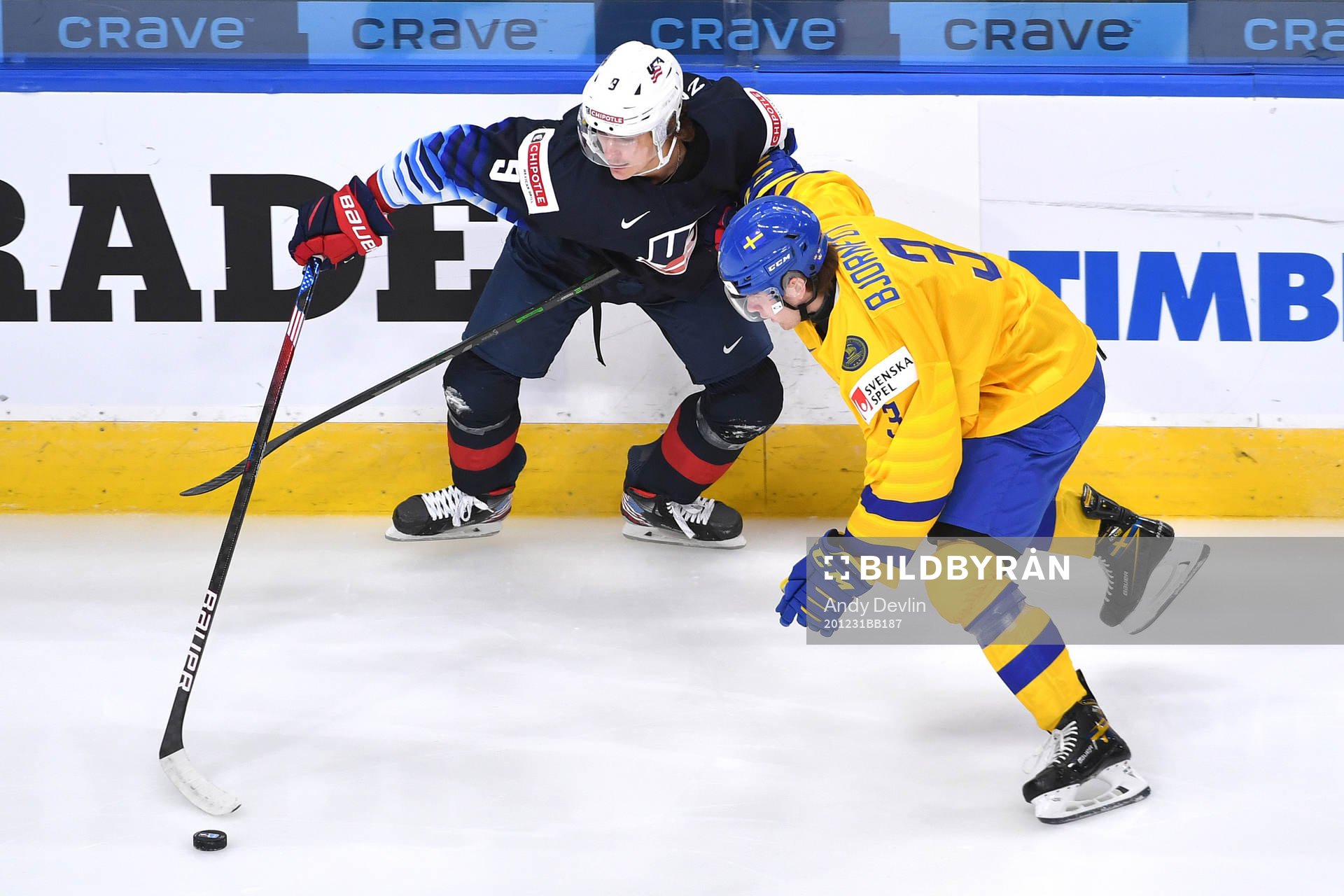 Tobias Björnfot of Sweden and Trevor Zegras of USA battle