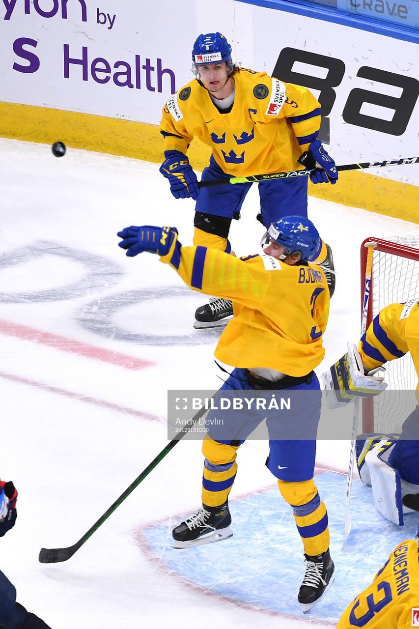 Tobias Björnfot of Sweden bats the puck away from the