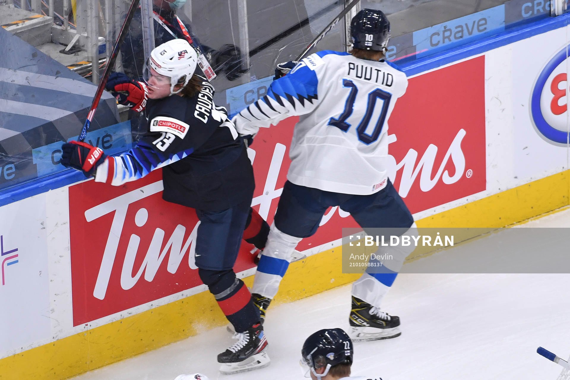 Kasper Puutio of Finland collides with Cole Caufield of USA