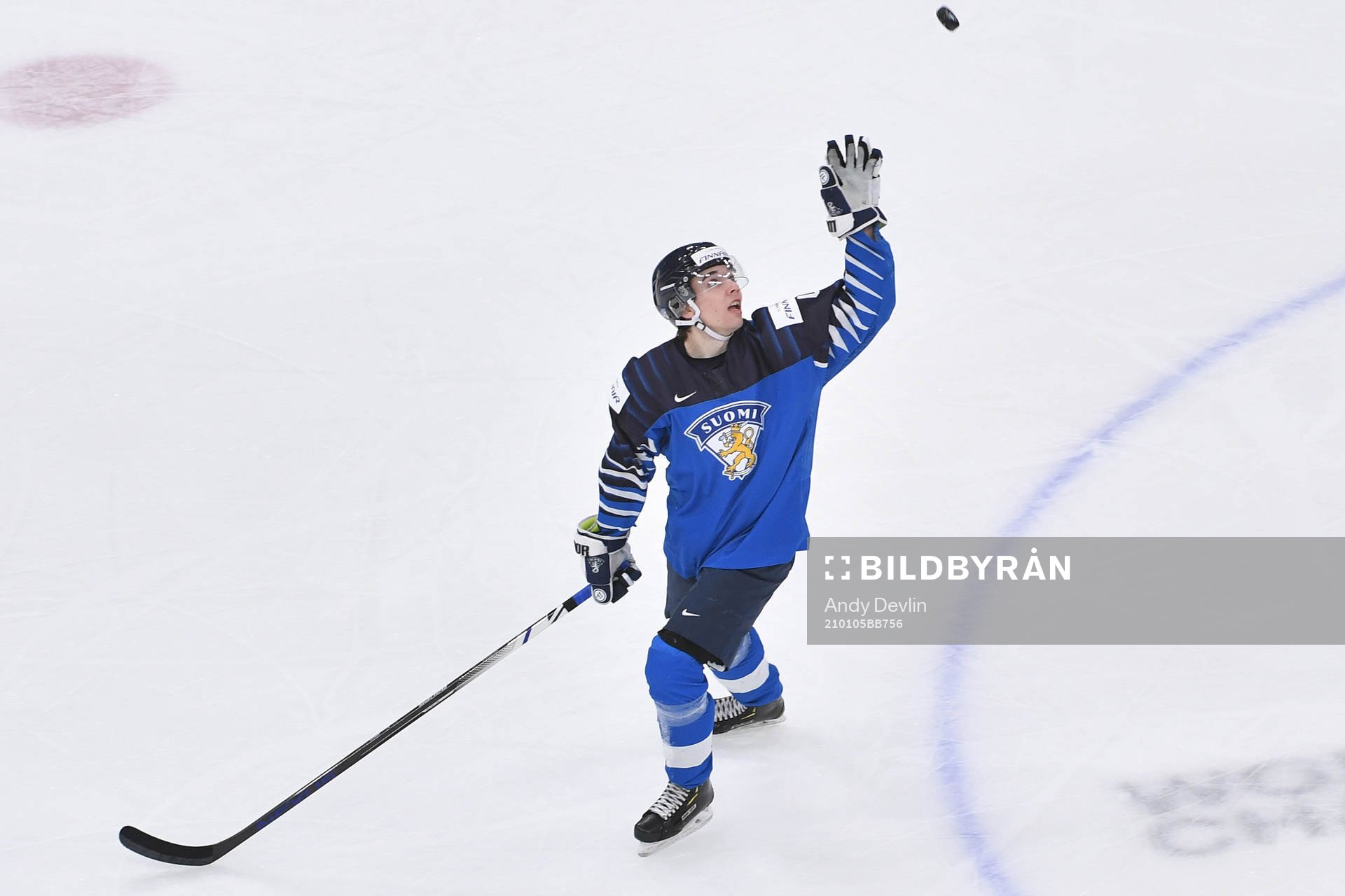 Ville Heinola of Finland reaches for a flying puck