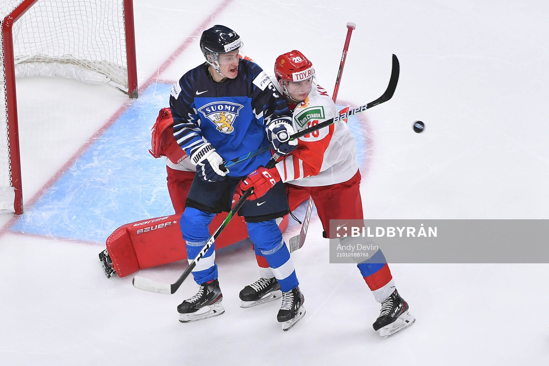 Benjamin Korhonen of Finland tires to defect a flying puck