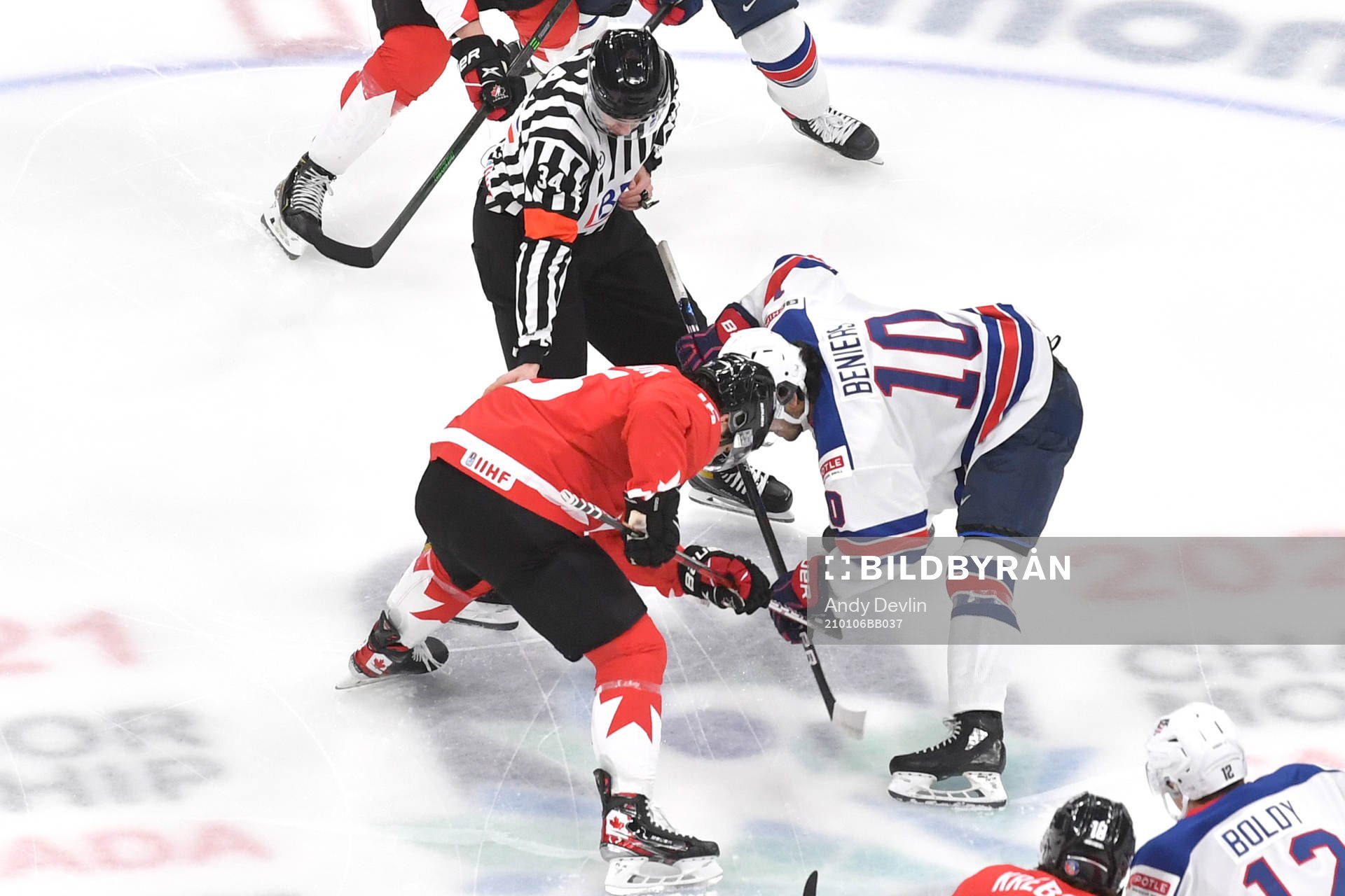 Alex Newhook of Canada takes the opening face-off against
