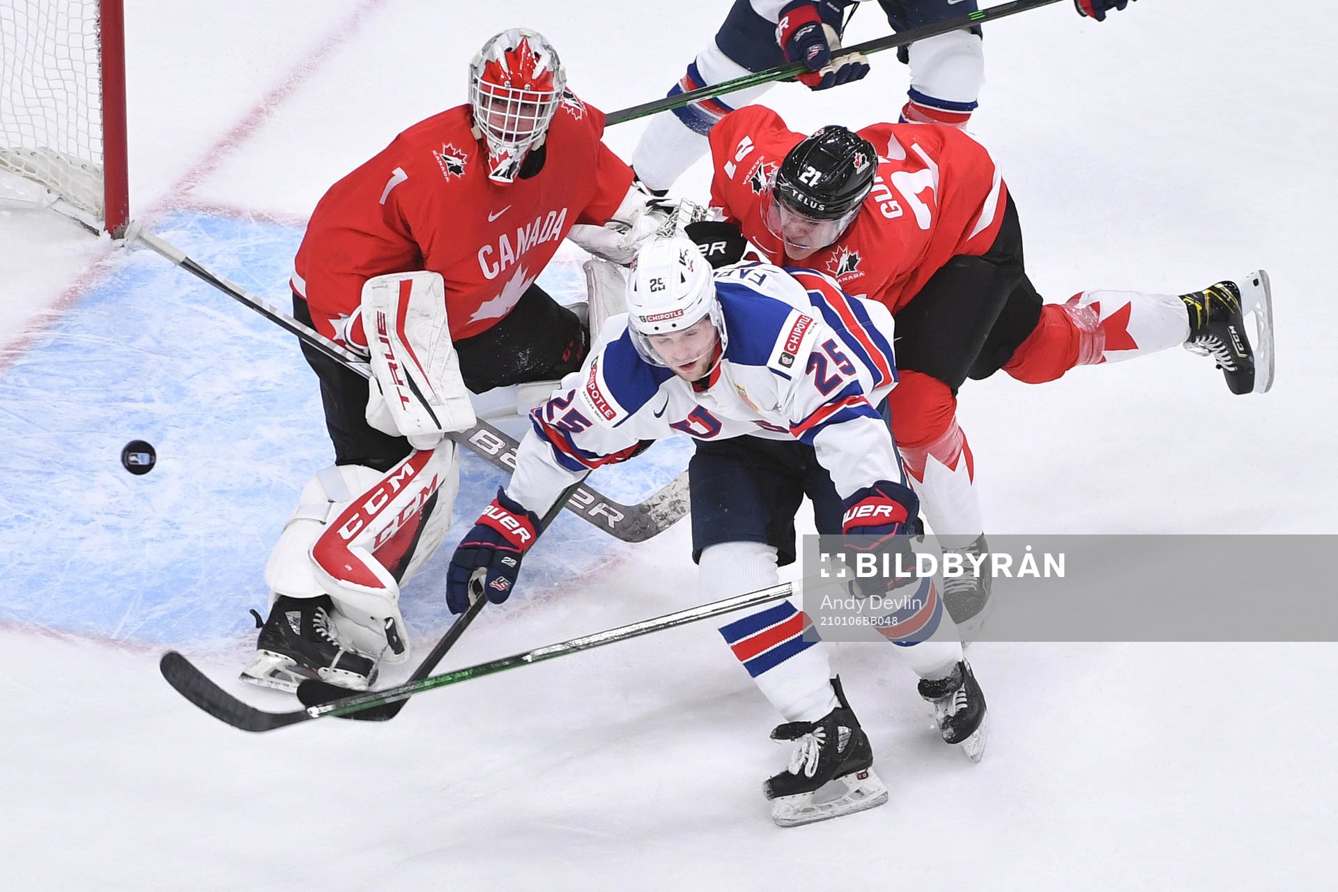 Devon Levi of Canada watches the puck fly through the air