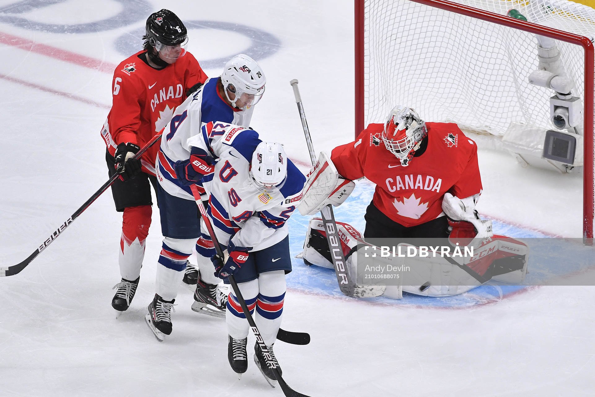 Devon Levi of Canada makes a save off a deflection from