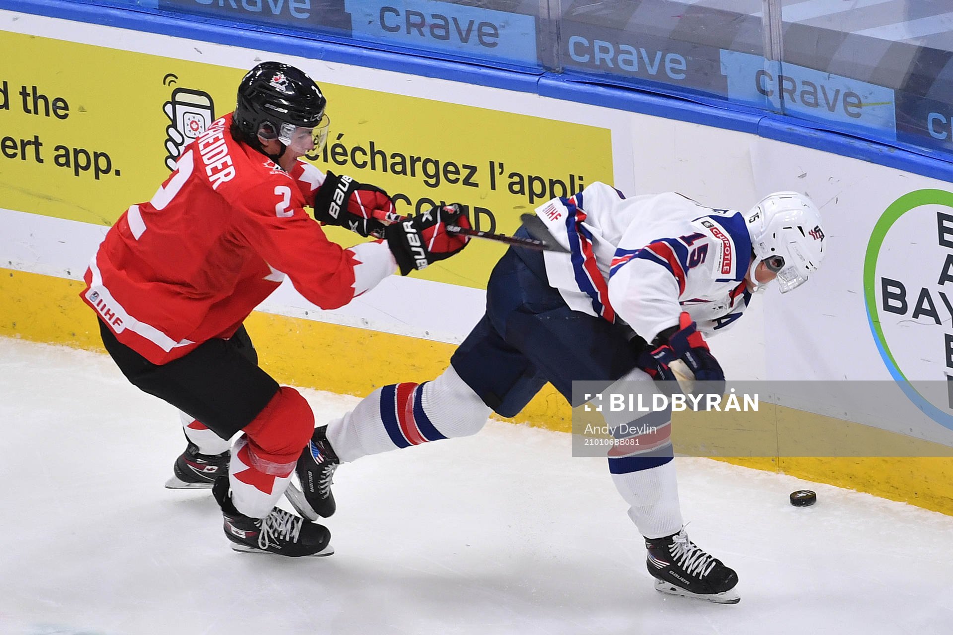 Braden Schneider of Canada battles for the puck in the