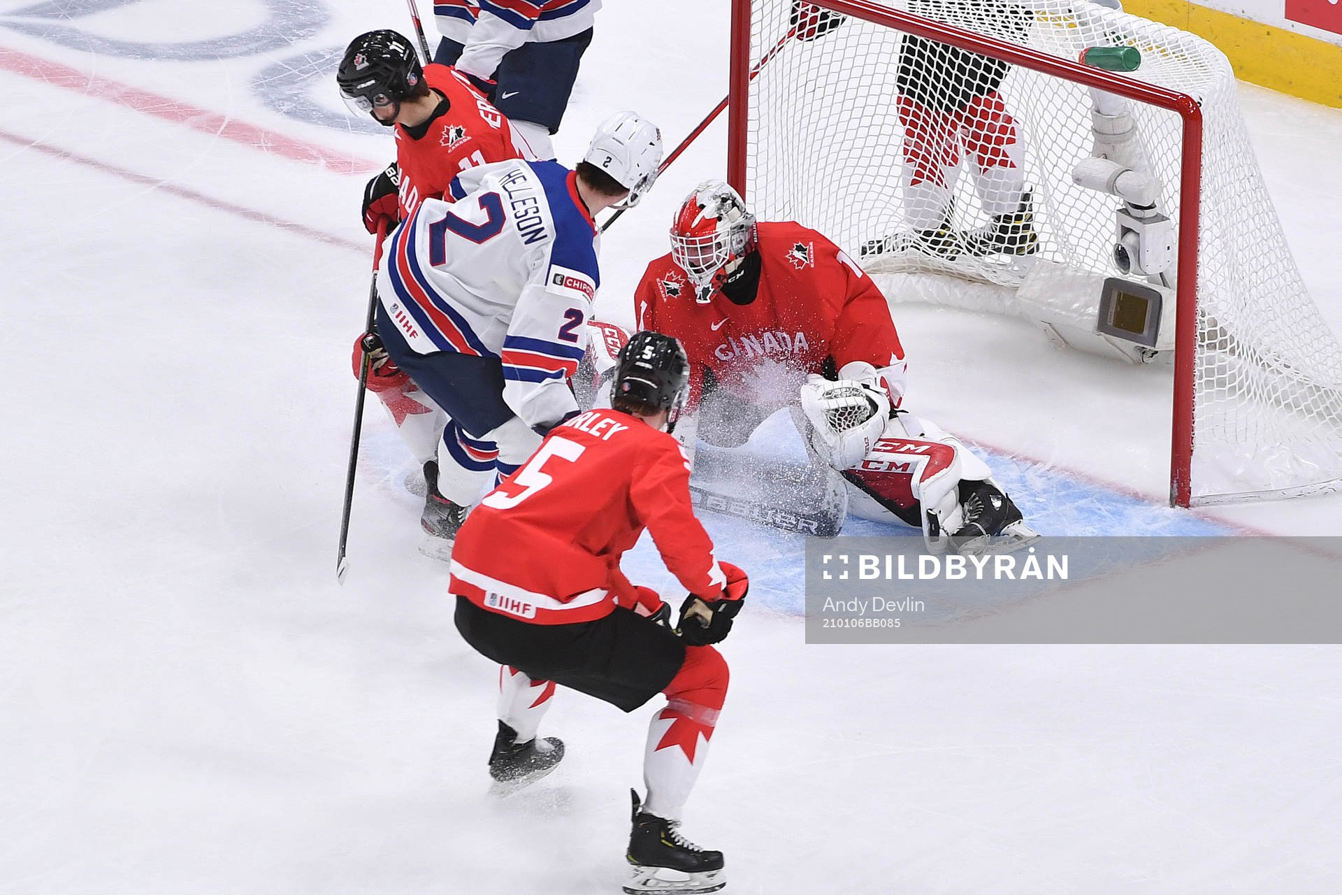 Devon Levi of canada makes a save as Drew Helleson of USA