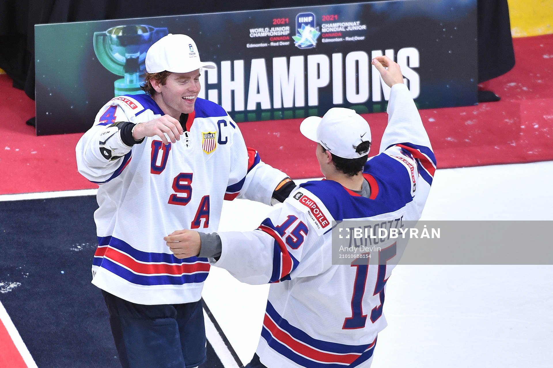 Cam York of USA hugs teammate Alex Turcotte