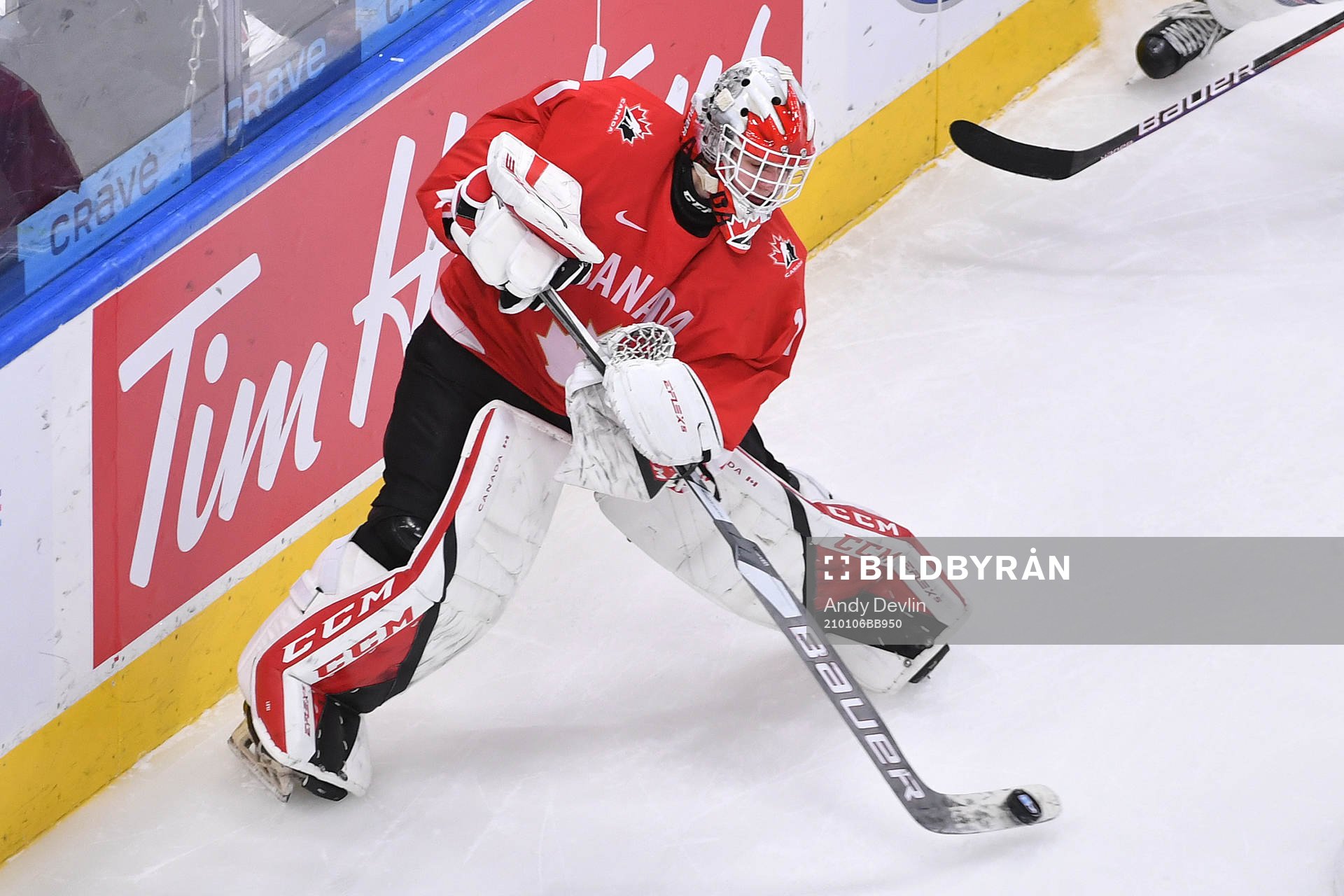 Devon Levi of Canada wanders out of his net to play the puck