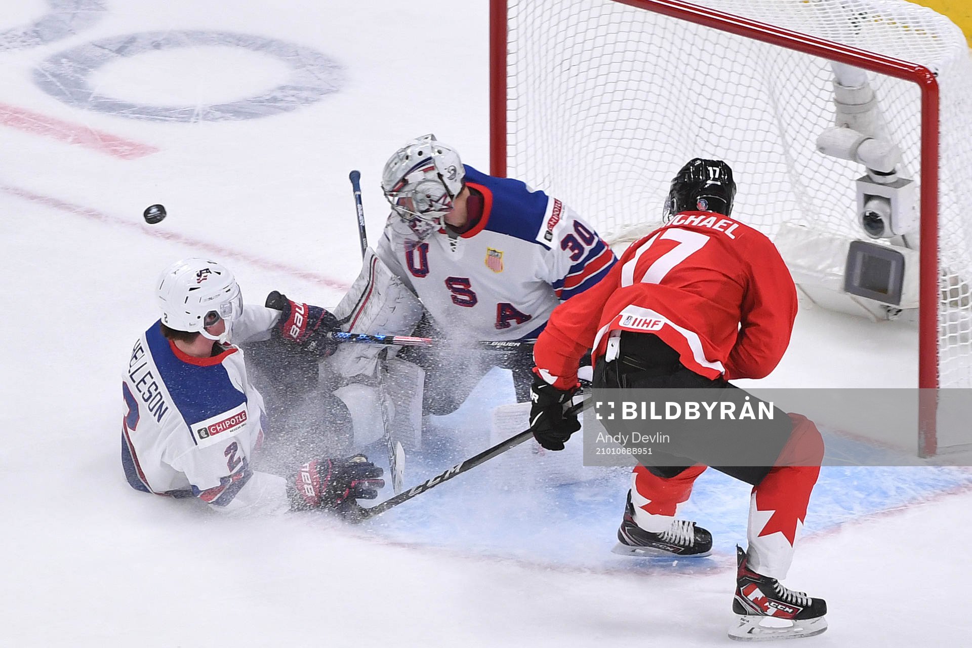 Drew Helleson of USA slides into his netminder Spencer