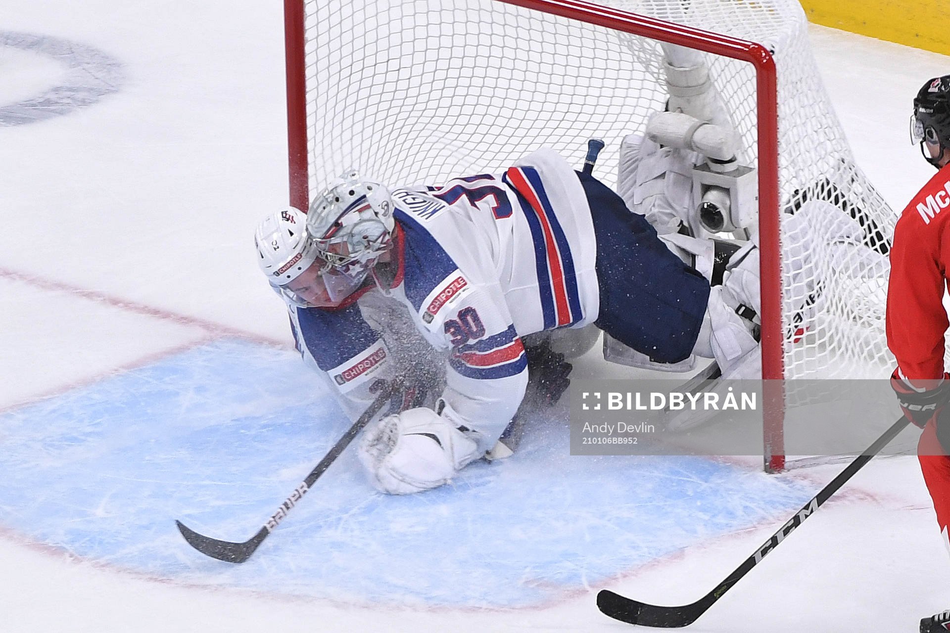 Drew Helleson of USA slides into his netminder Spencer