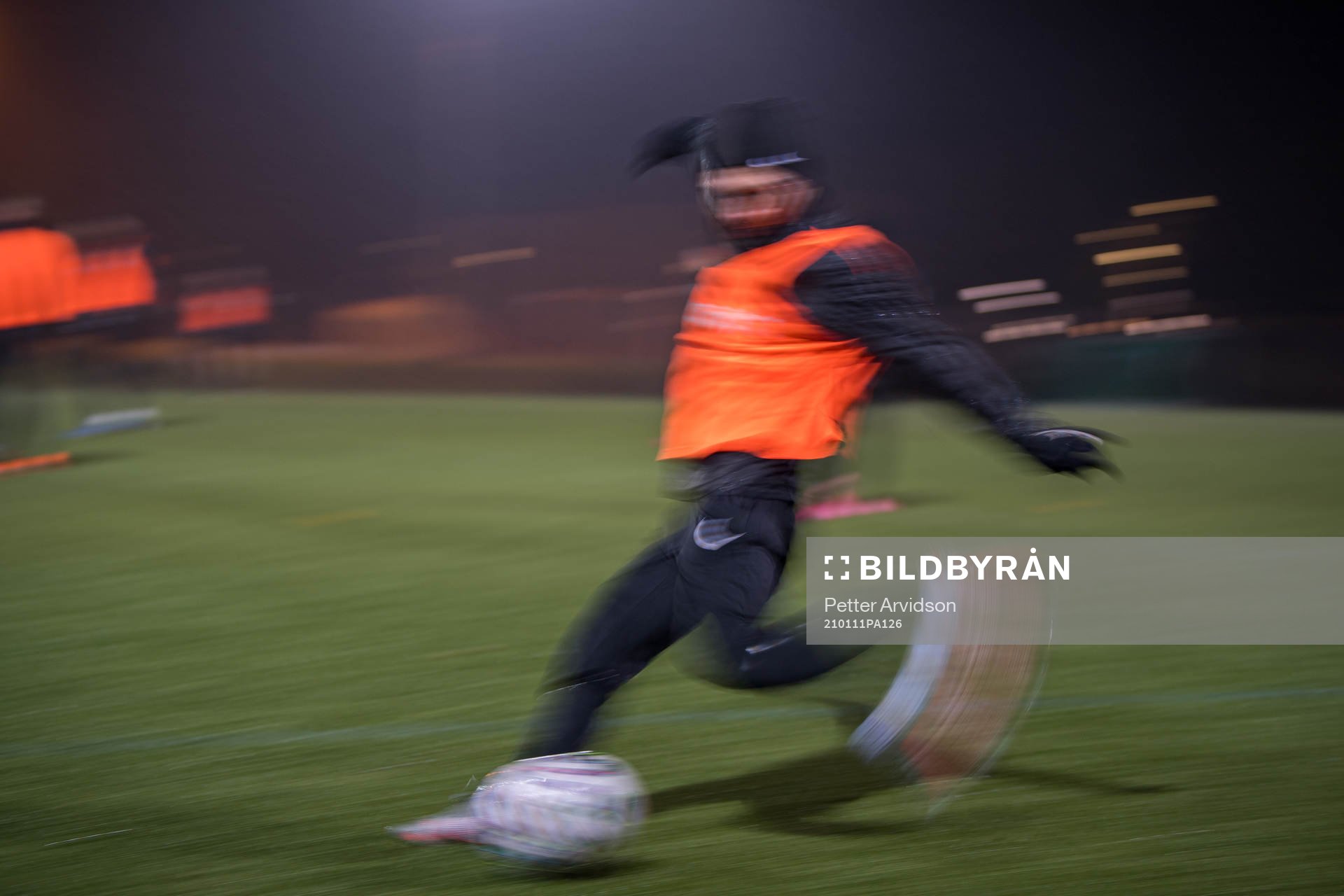 En fotbollsspelare i rörelseoskärpa sparkar på en boll