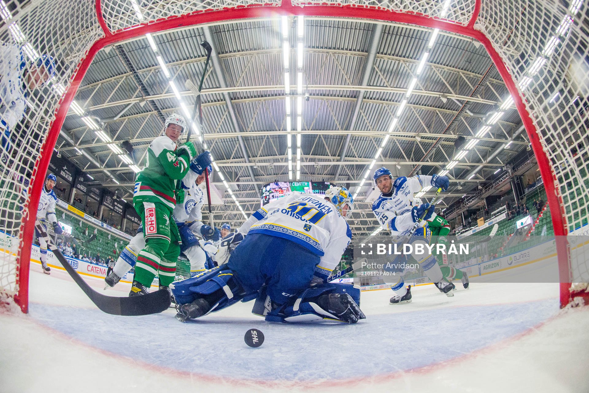 Rögles Olli Palola ser pucken rulla bakom Leksands