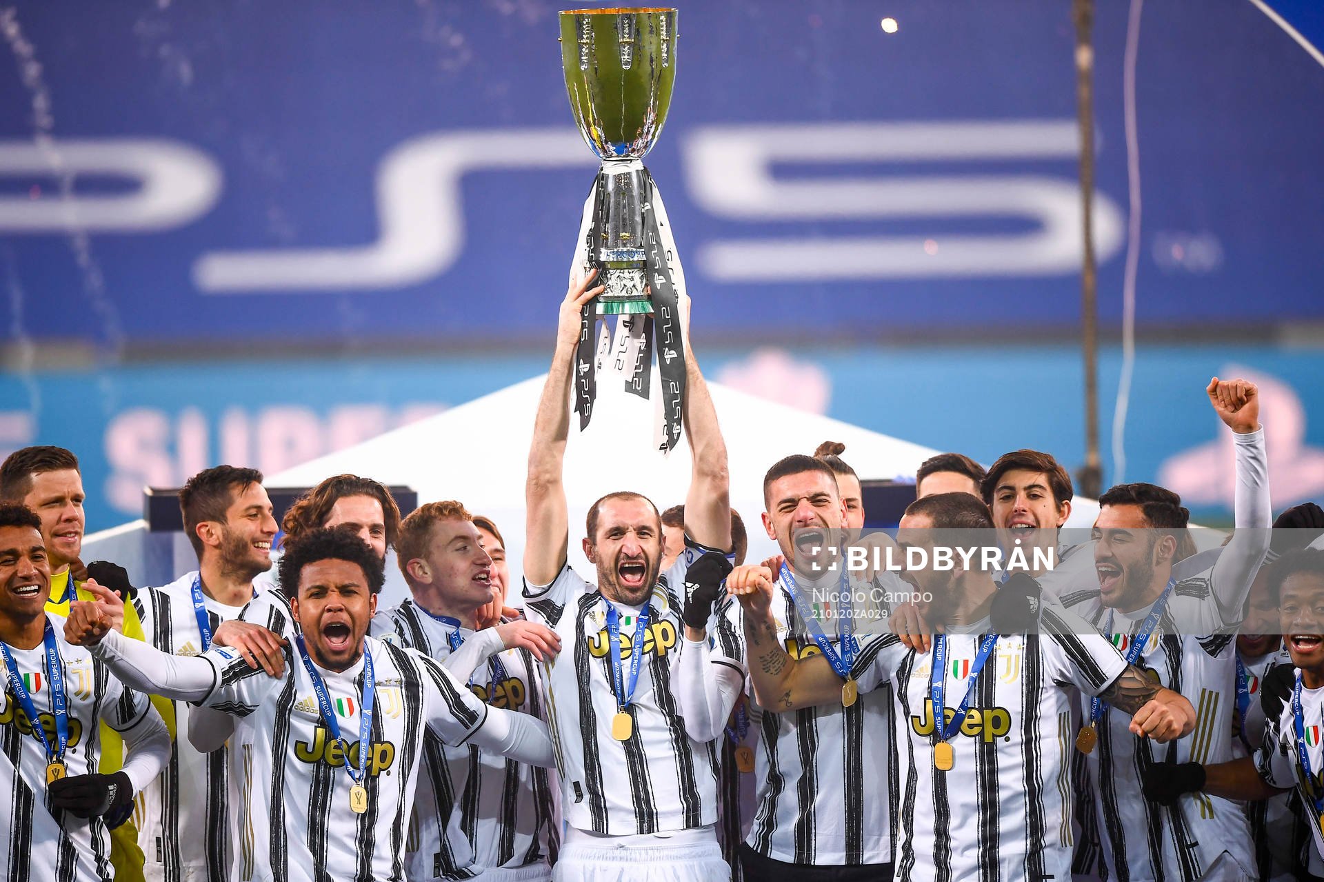 Dejan Kulusevski and Giorgio Chiellini of Juventus celebrates with the trophy after Juventus won the italian super cup final against Napoli on January 20, 2021 in Turin, Italy.