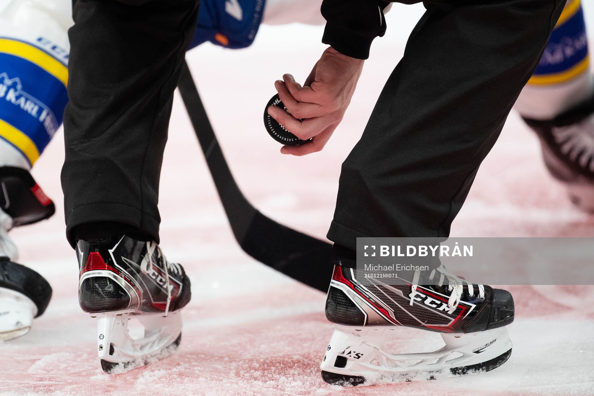 Linjedomare Johan Löfgren med pucken vid tekning