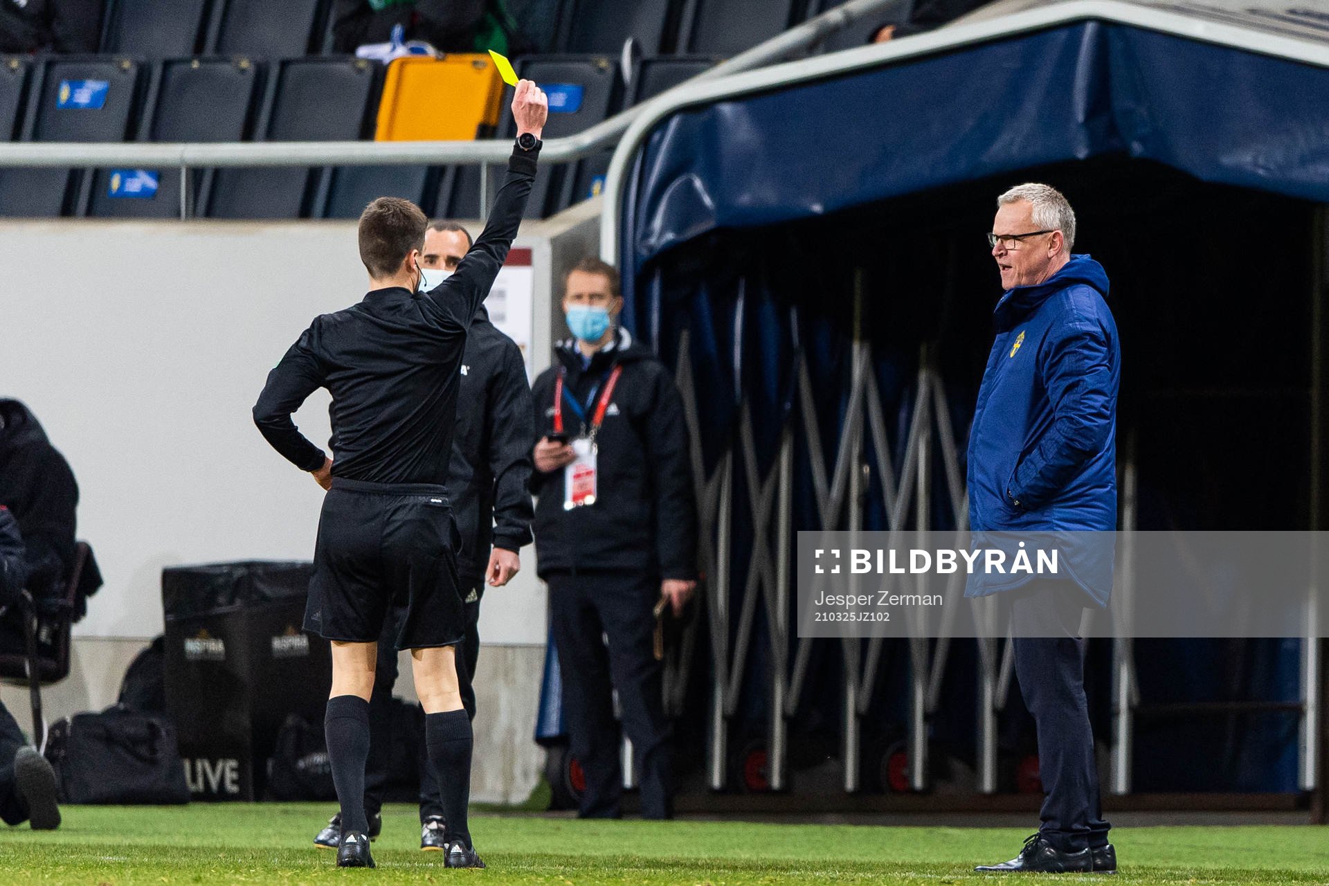 Referee Bastien Benoit awards a yellow card to Janne