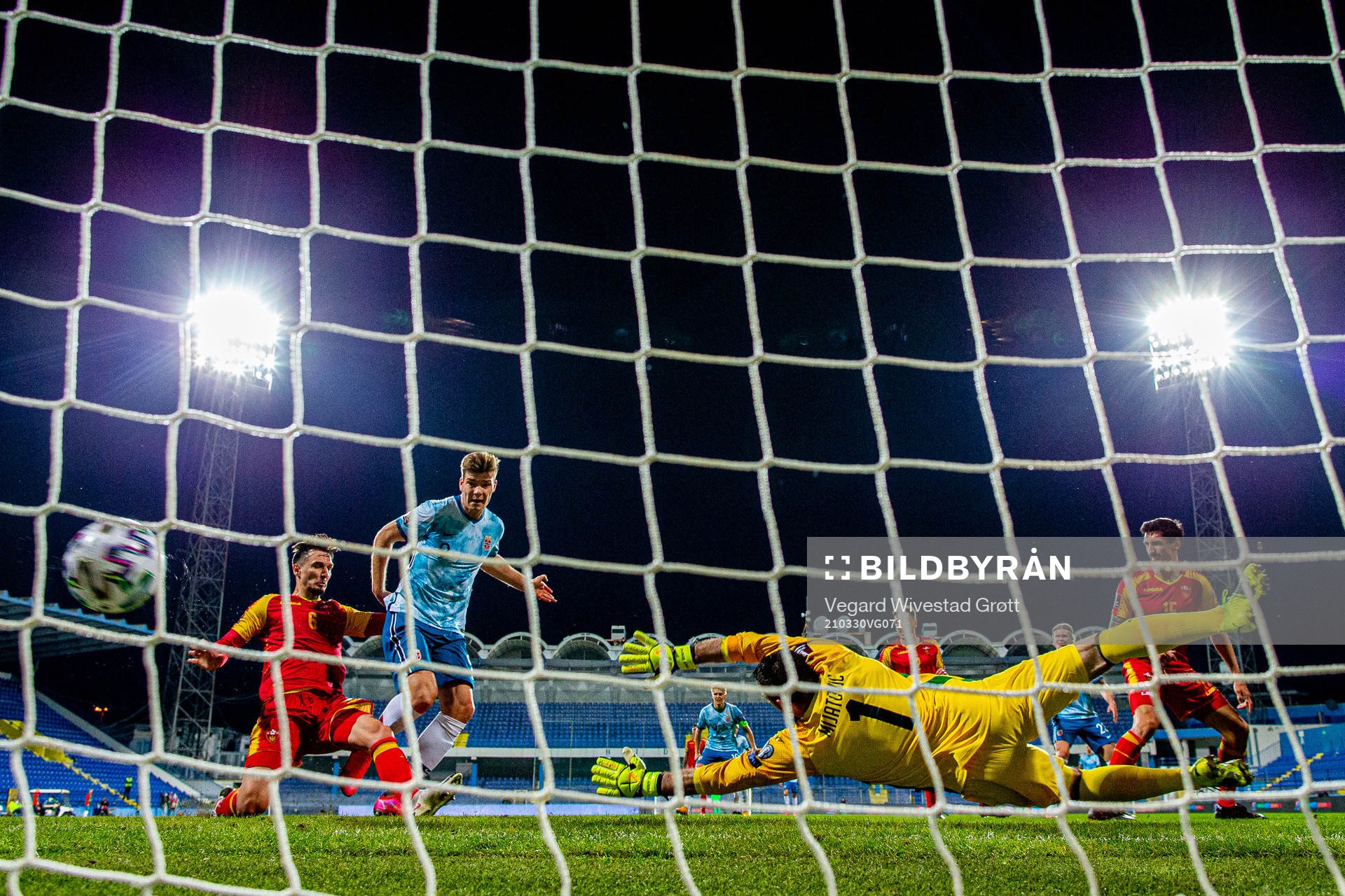 Alexander Sørloth of Norway scores the 0-1 goal past Zarko Tomasevic and goalkeeper Milan Mijatovic of Montenegro during the FIFA World Cup Qualifier football match between Montenegro and Norway on March 30, 2021 in Podgorica.