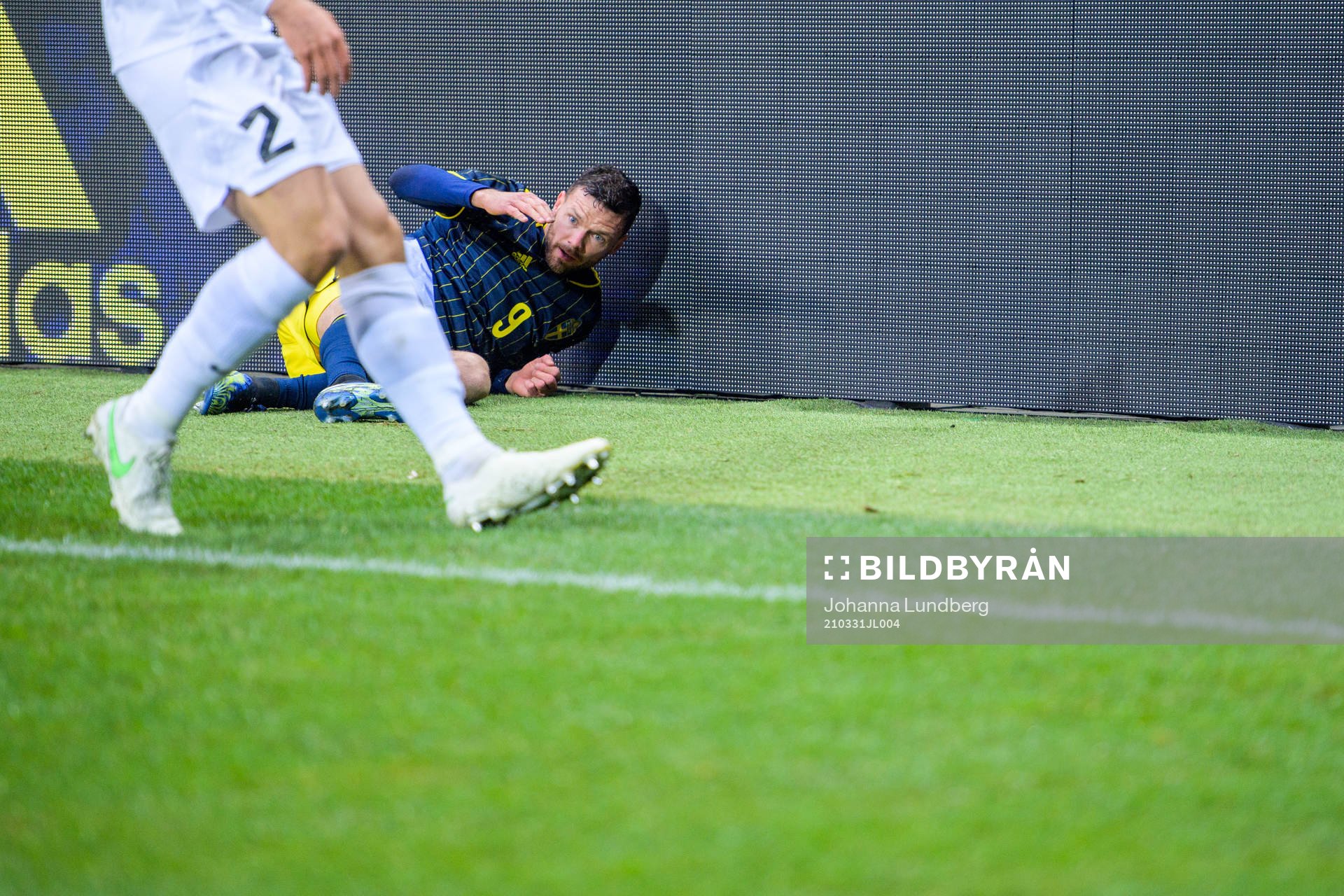 Marcus Berg of Sweden fall into a commercial sign