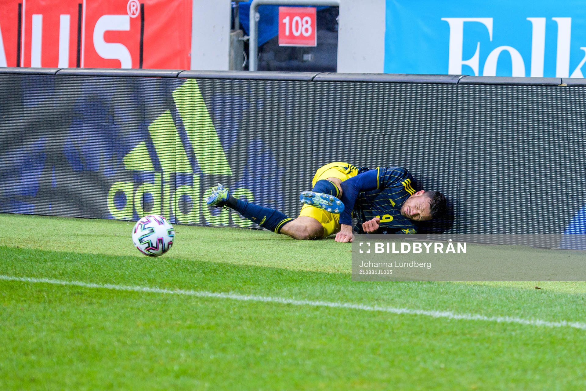 Marcus Berg of Sweden fall into a commercial sign