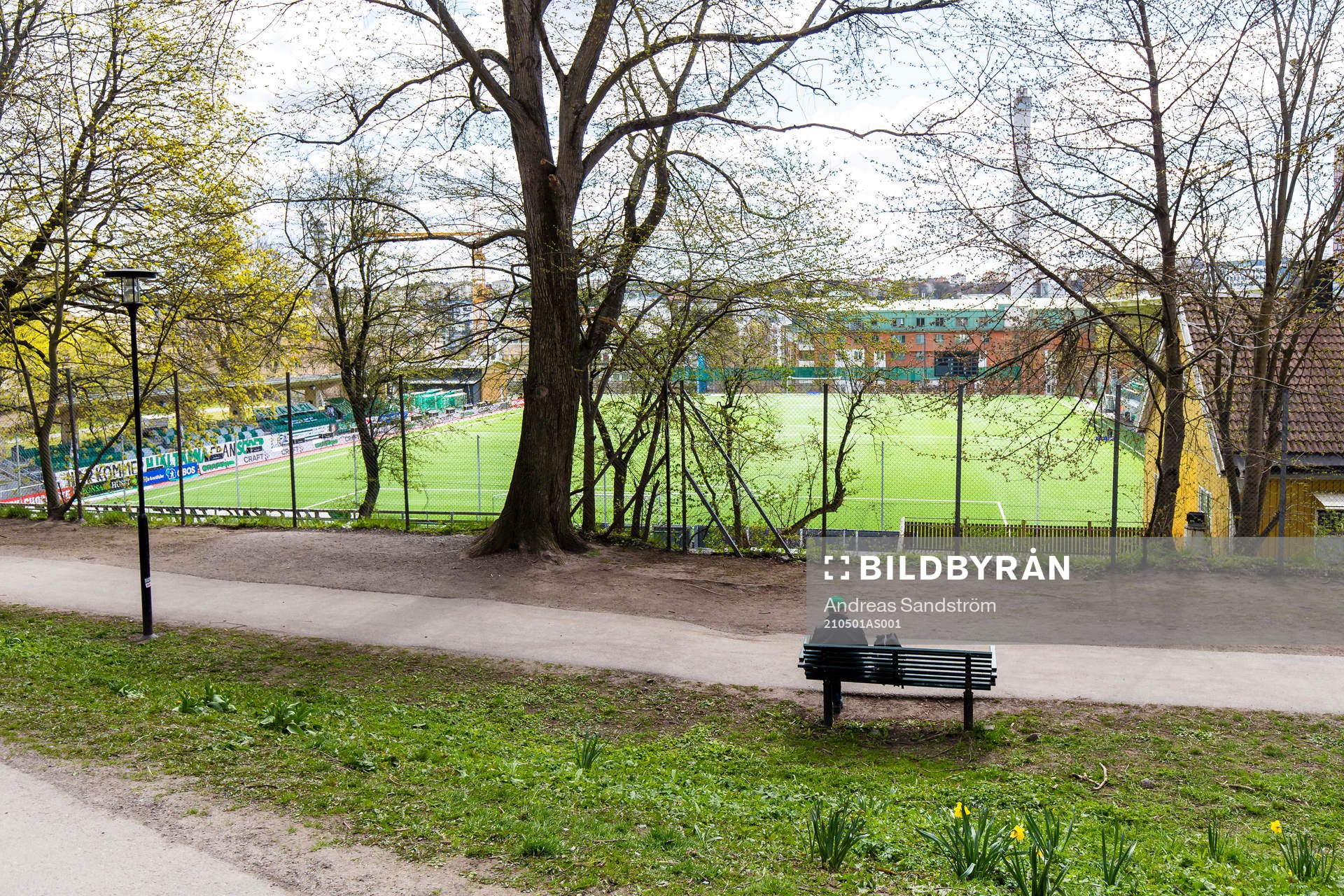 En man i Hammarbykeps sitter på en parkbänk utanför