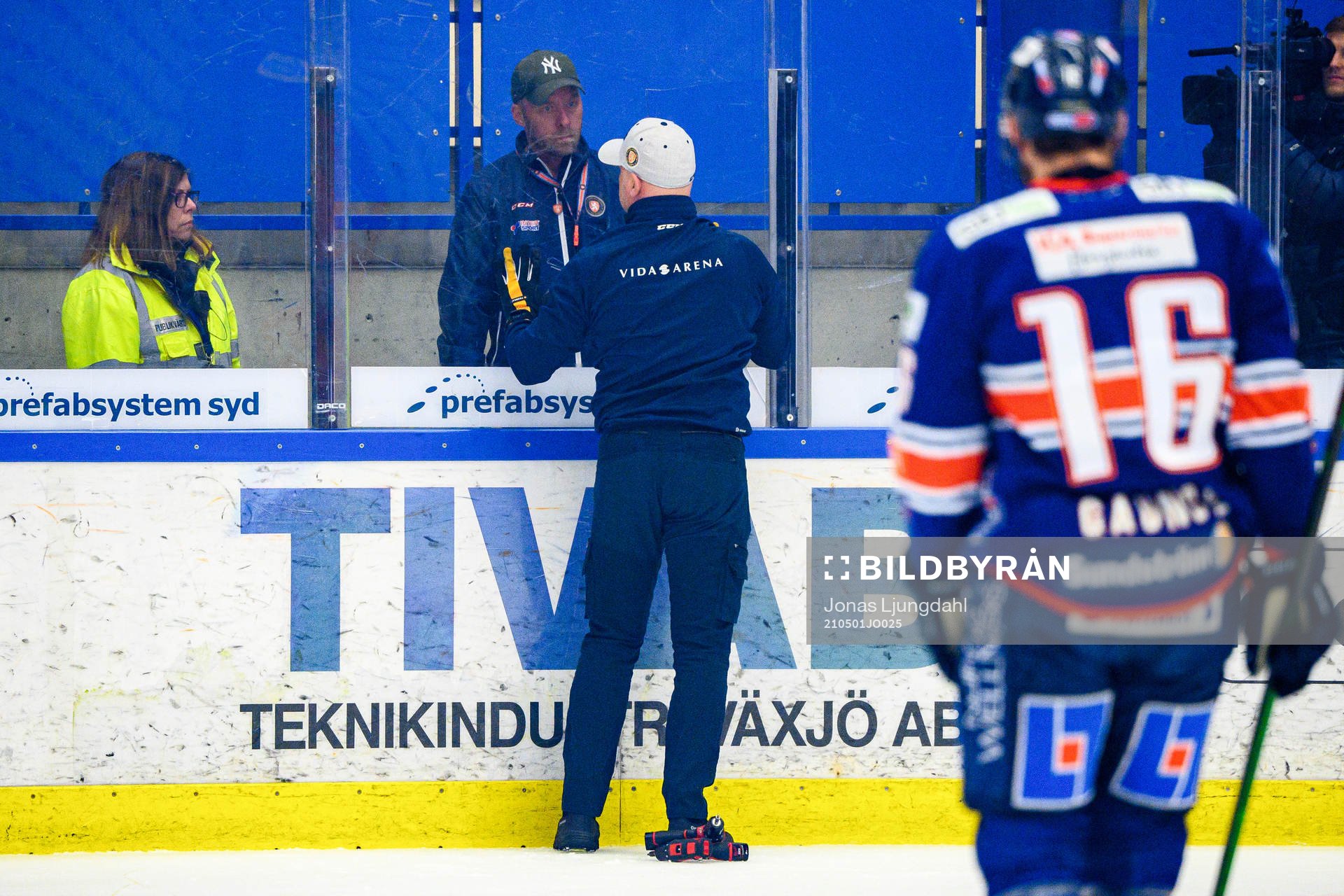 En vaktmästare lagar ett trasigt plexiglas