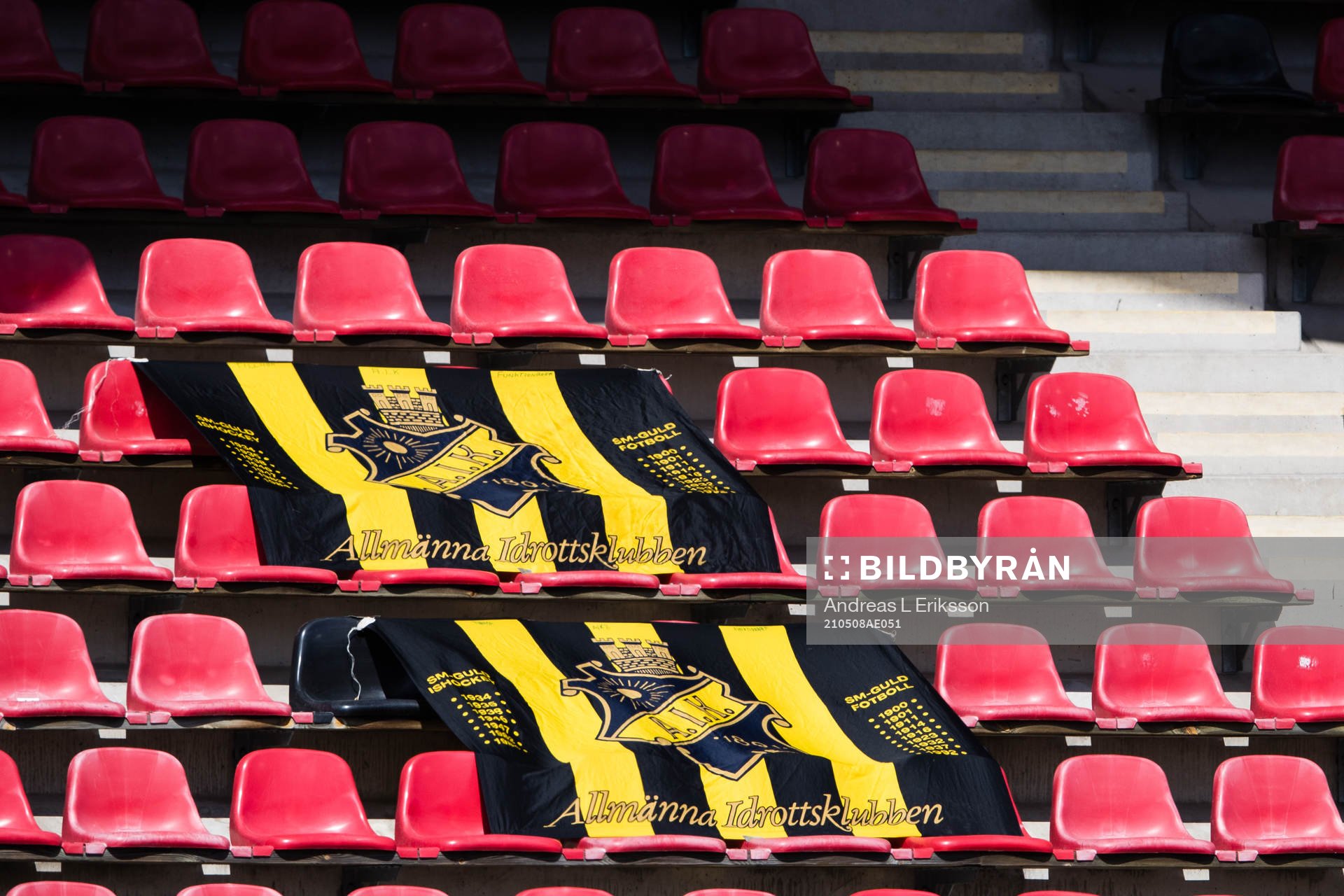 Tomma läktare med AIK-flaggor innan fotbollsmatchen i