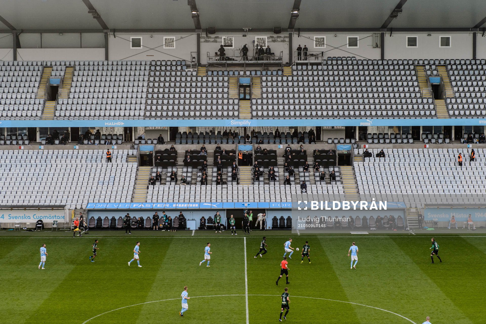 Spel pågår framför pressläktaren och de tomma läktaren pga publikbegräsningar under Covid-19, coronapandemin under fotbollsmatchen i Allsvenskan mellan Malmö FF och Varberg den 9 maj 2021 i Malmö.