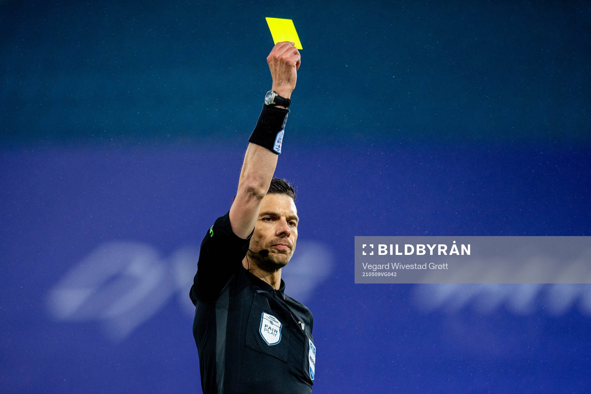 Tore Hansen, referee, hands out a yellow card