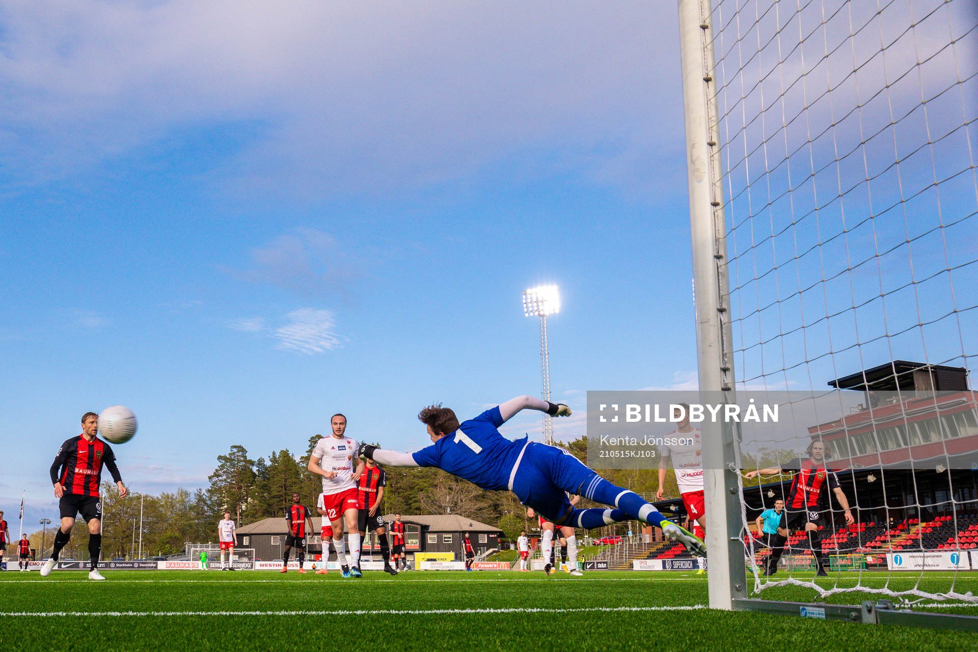 Brommapojkarnas Simon Helg gör 4-0 bakom Hudiksvalls målvakt Sebastian Jonsson under fotbollsmatchen i Division 1 Norra mellan Brommapojkarna och Hudiksvall den 15 maj 2021 i Stockholm.