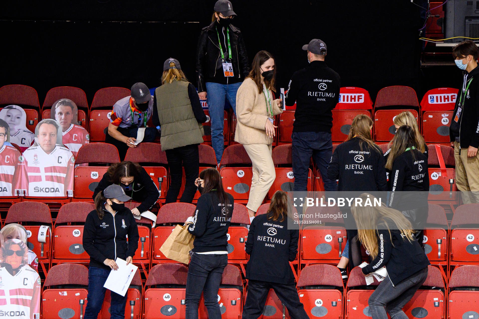 Members of the staff prepare seat positions for fans of the