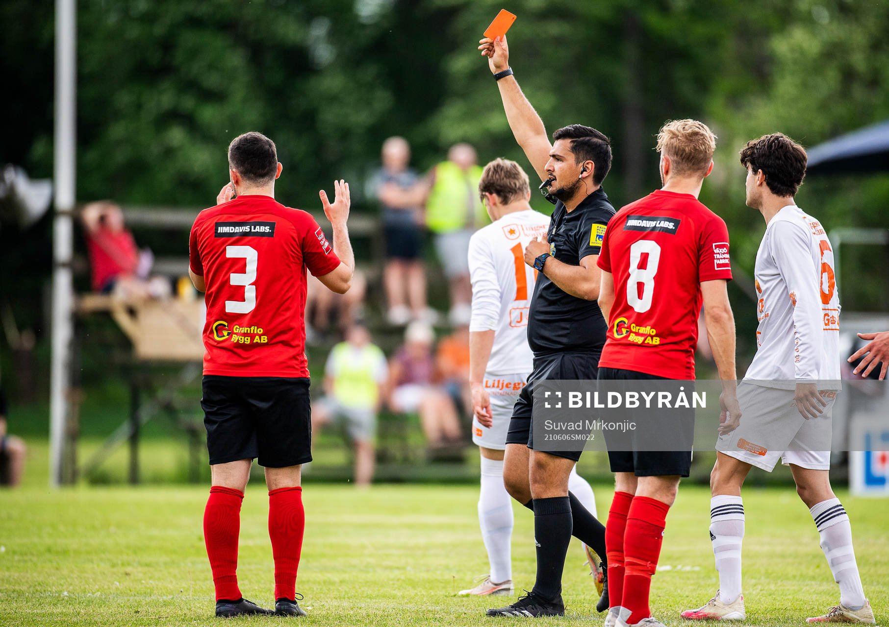 Domare Delavar Vahdanjo ger rött kort till Åryds Elvedin Mesinovic under fotbollsmatchen i division 3 sydöstra götaland mellan Älmeboda/Linneryd och Åryd den 6 juni 2021 i Rävemåla.